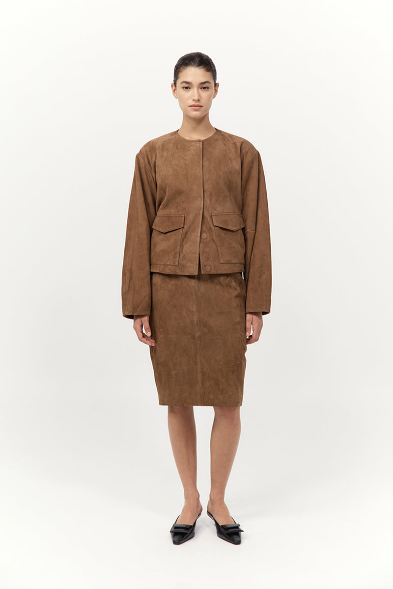 Person wearing a brown suede suit on a white background