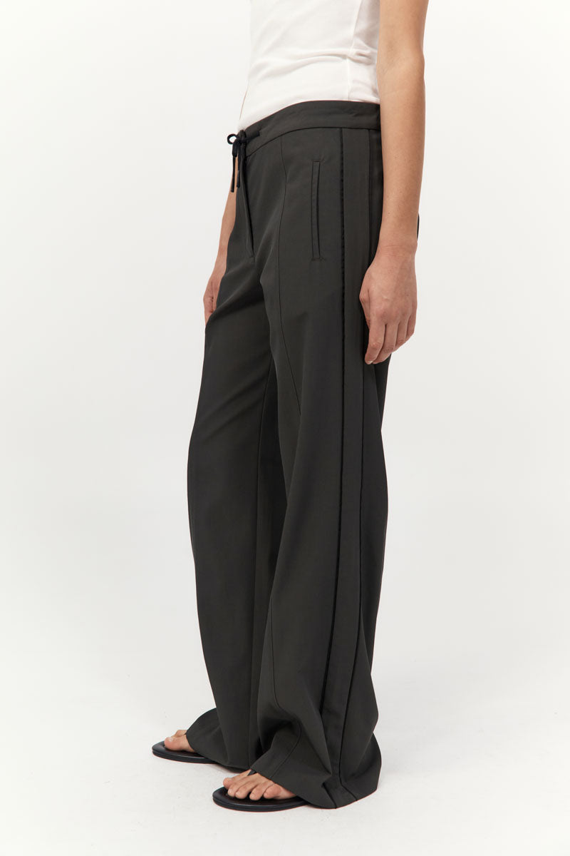 Person wearing black wide-leg pants on a white background