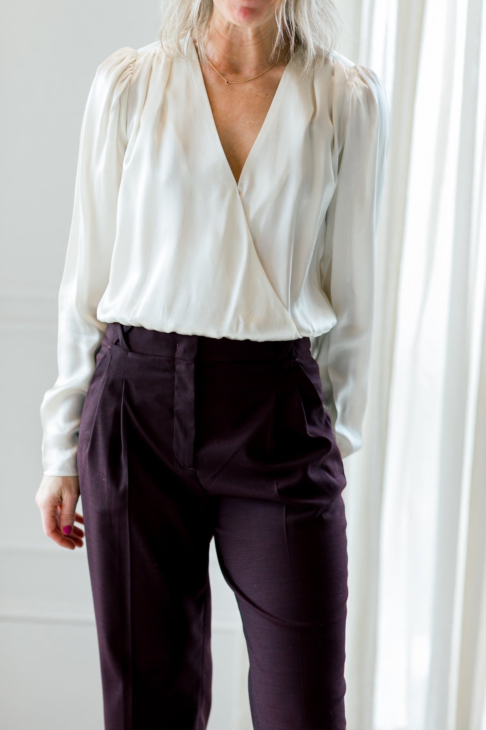 image of a woman wearing the garment catania blouse in cream and necchi pants