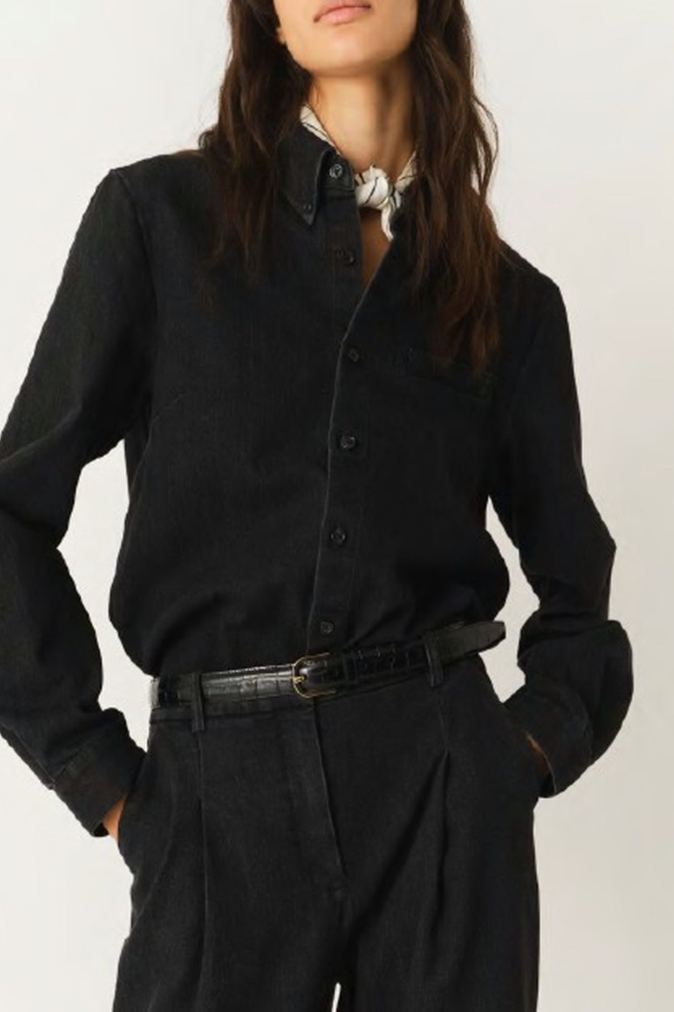 Person wearing a black shirt and dark pants against a white background