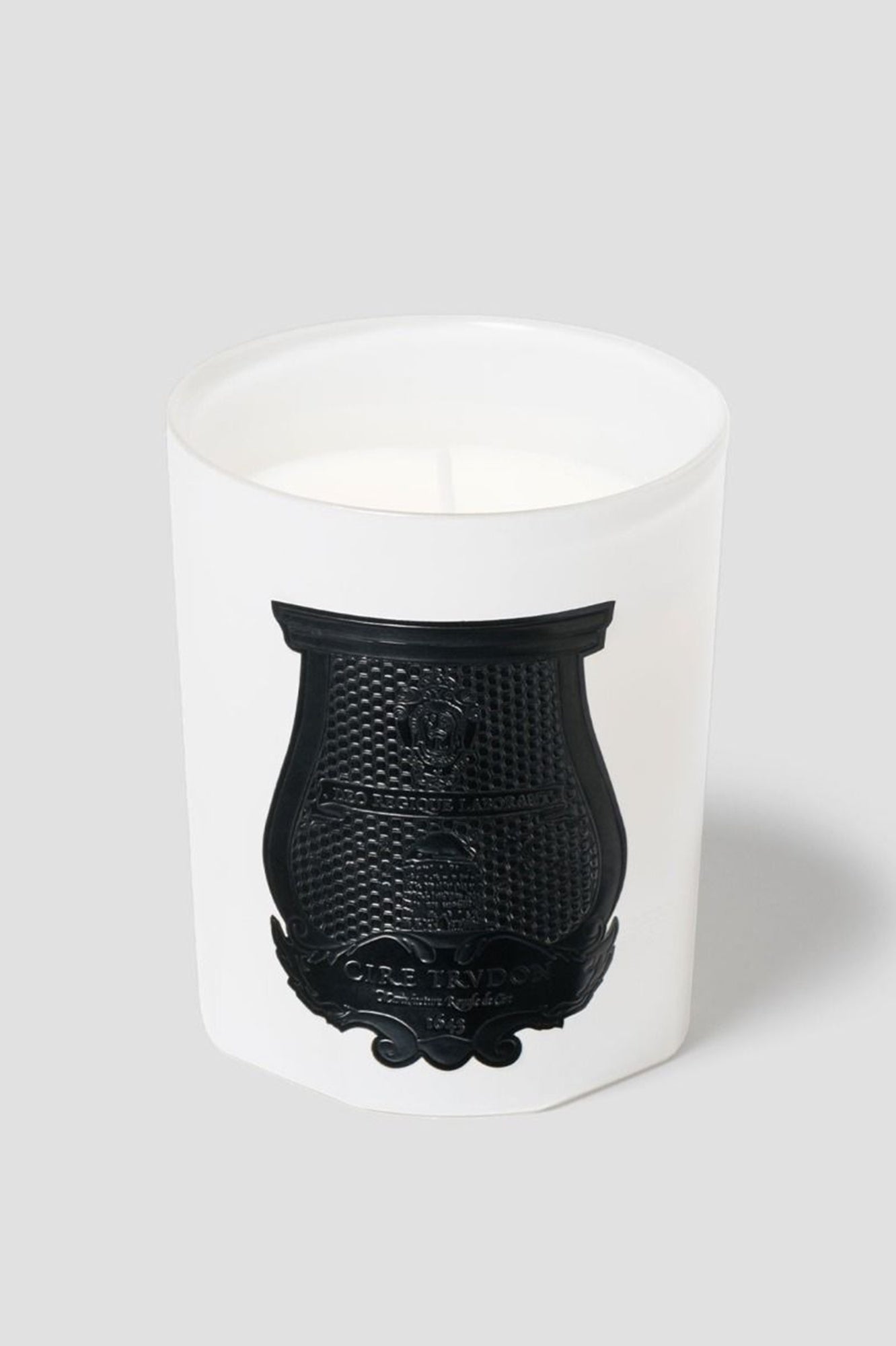 White candle with black decorative base on a white background