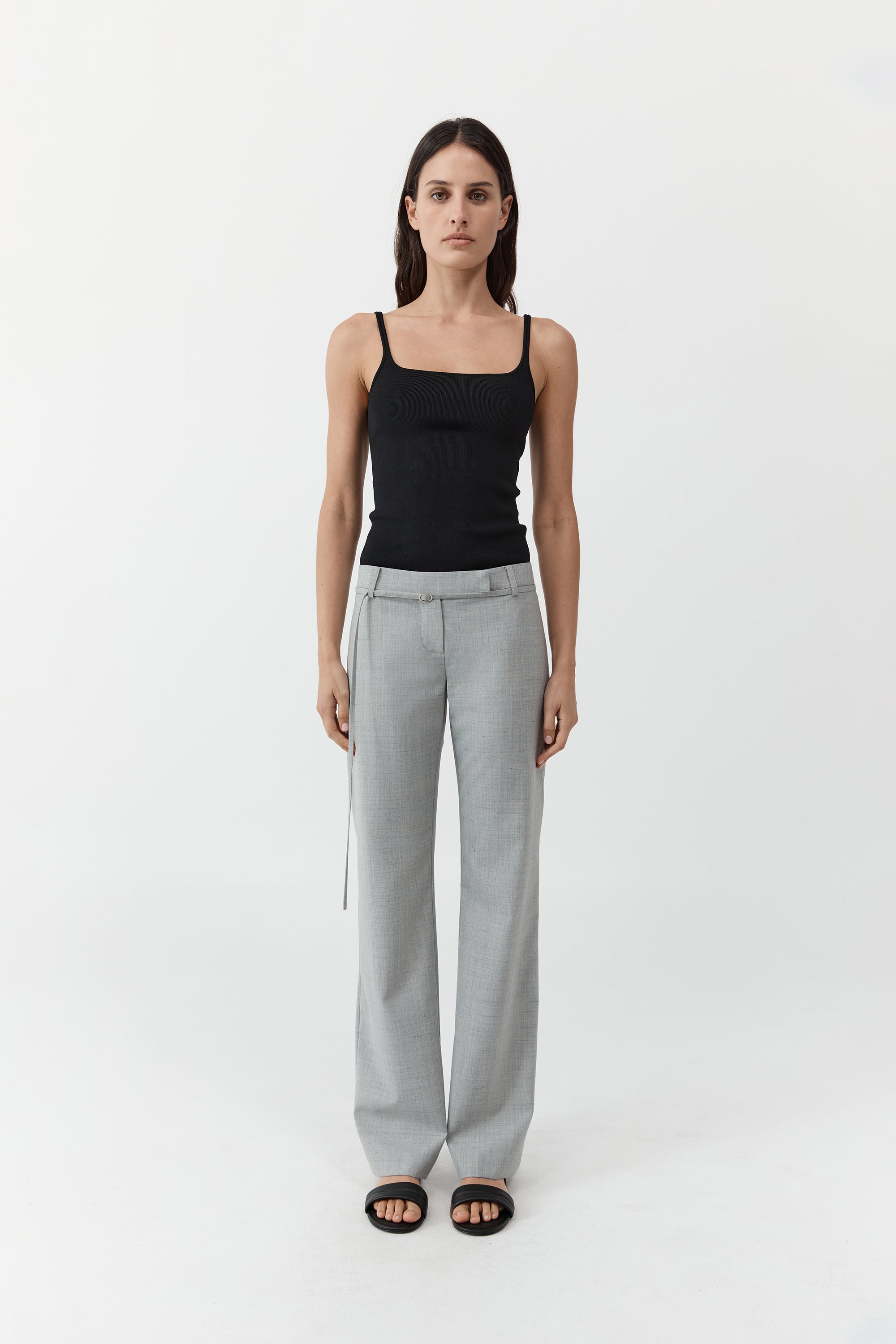 Woman wearing the st. agni slim square neck top In black with gray trousers in front of a cream background