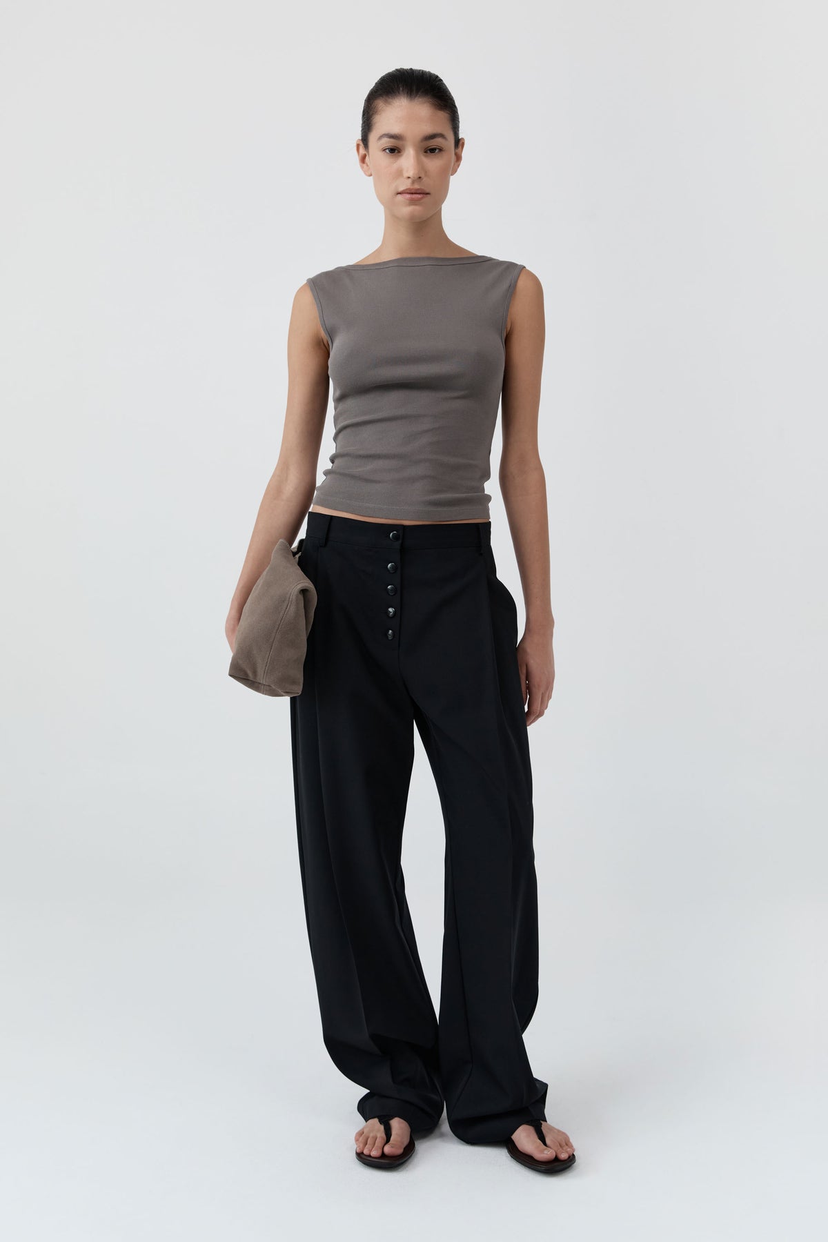 Woman wearing St Agni Organic Cotton Ballerina Top in clay and black pants standing against a white background