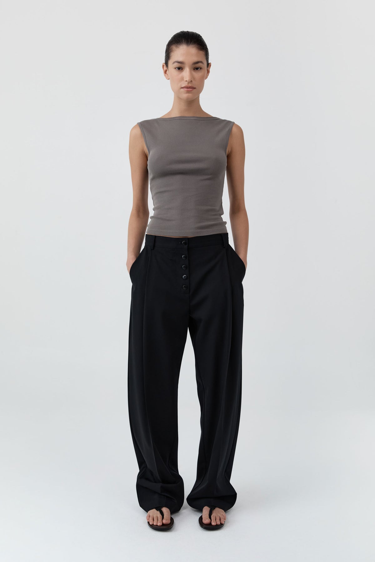Woman wearing St Agni Organic Cotton Ballerina Top in clay and black pants standing against a white background