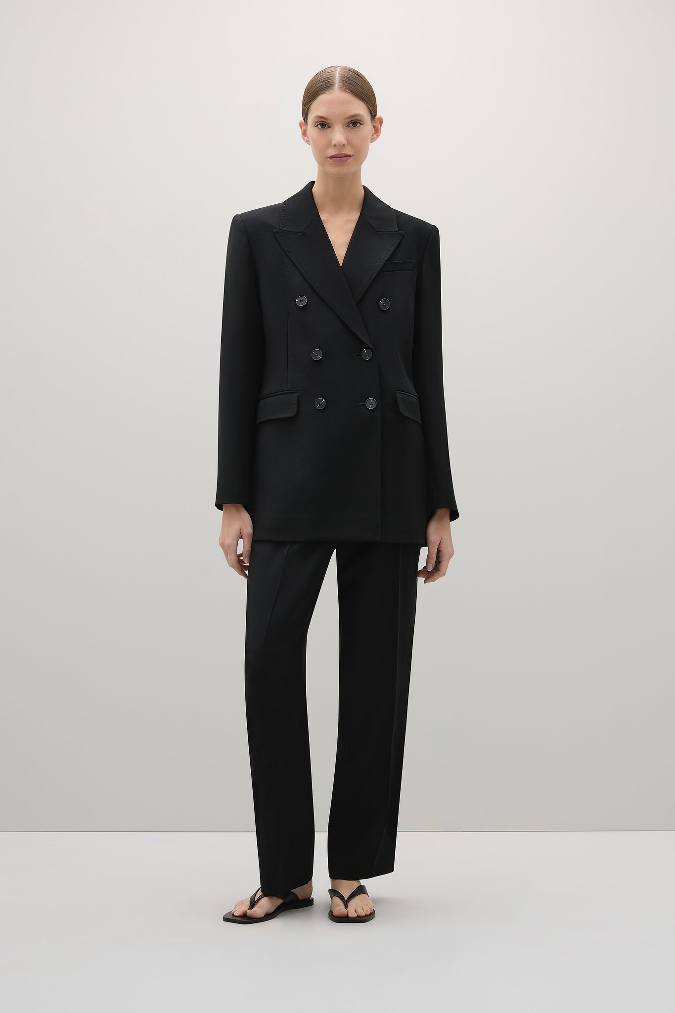 Woman wearing a black suit on a white background