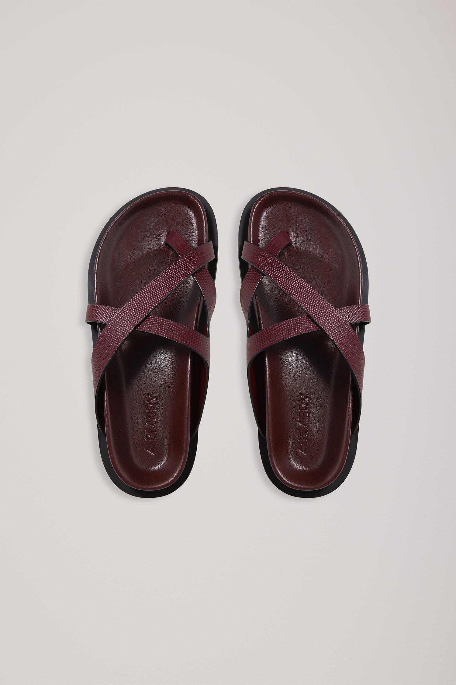Pair of maroon sandals on a light gray background