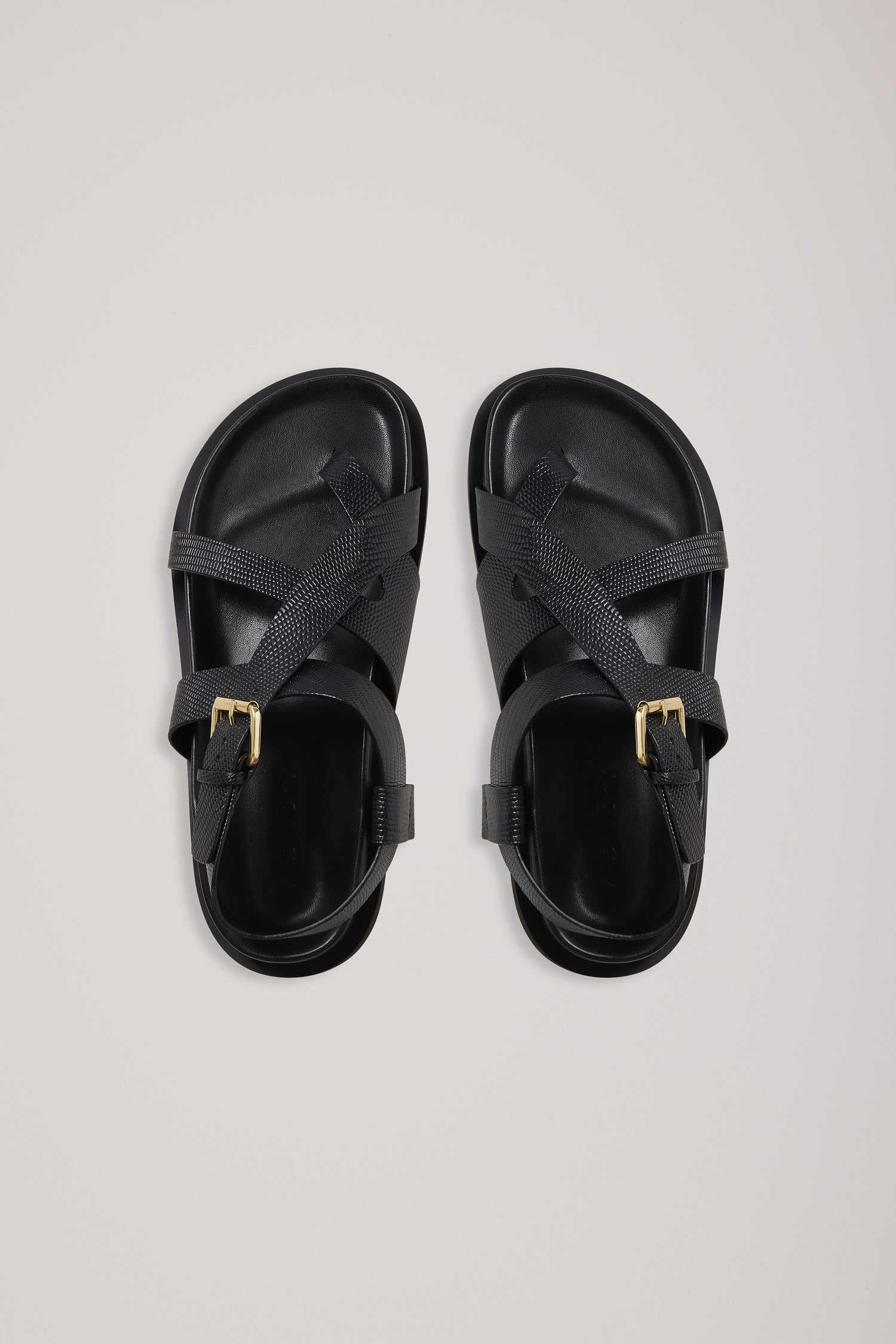 Pair of black sandals on a light gray background