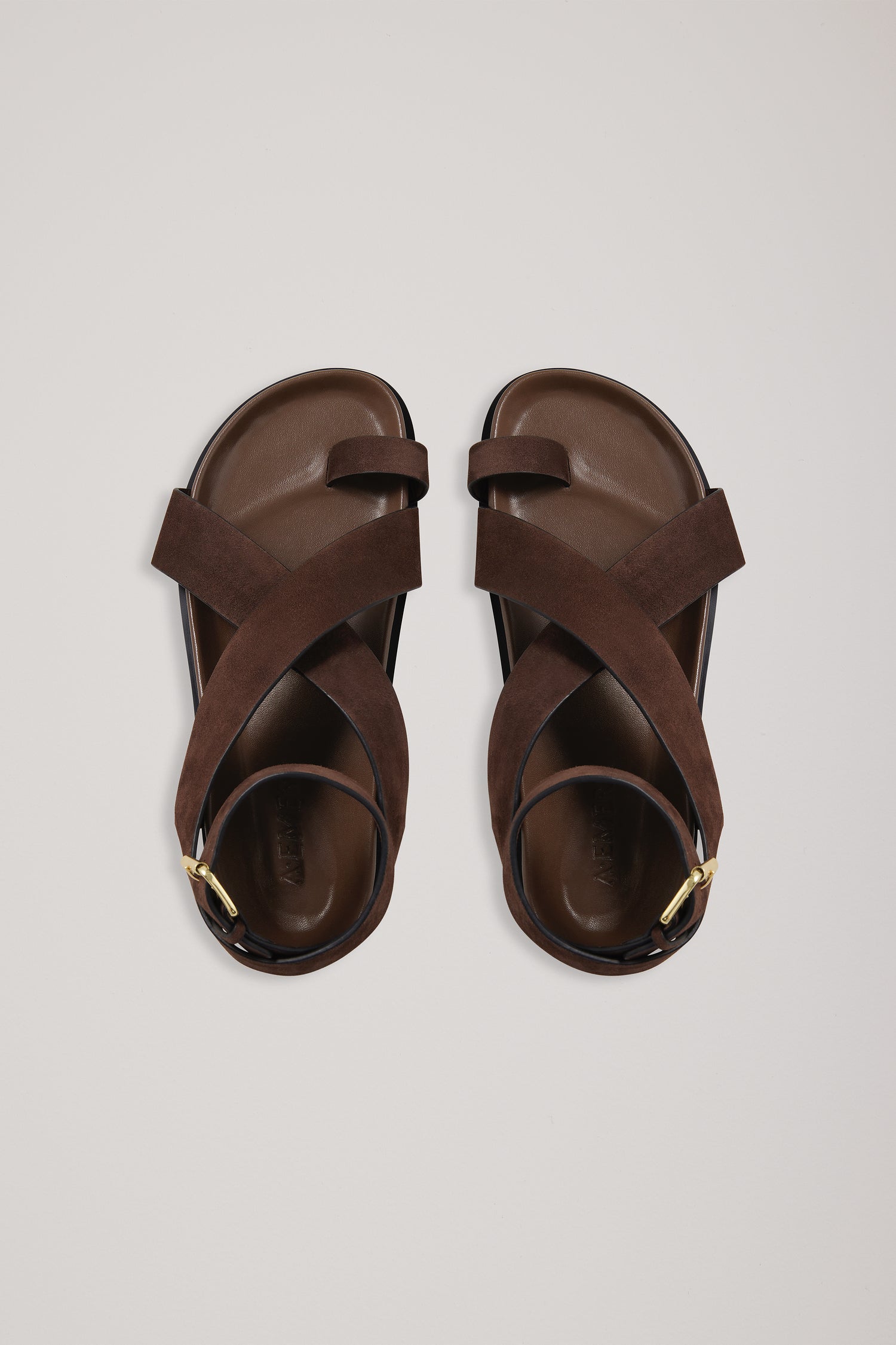 Pair of brown sandals on a light gray background