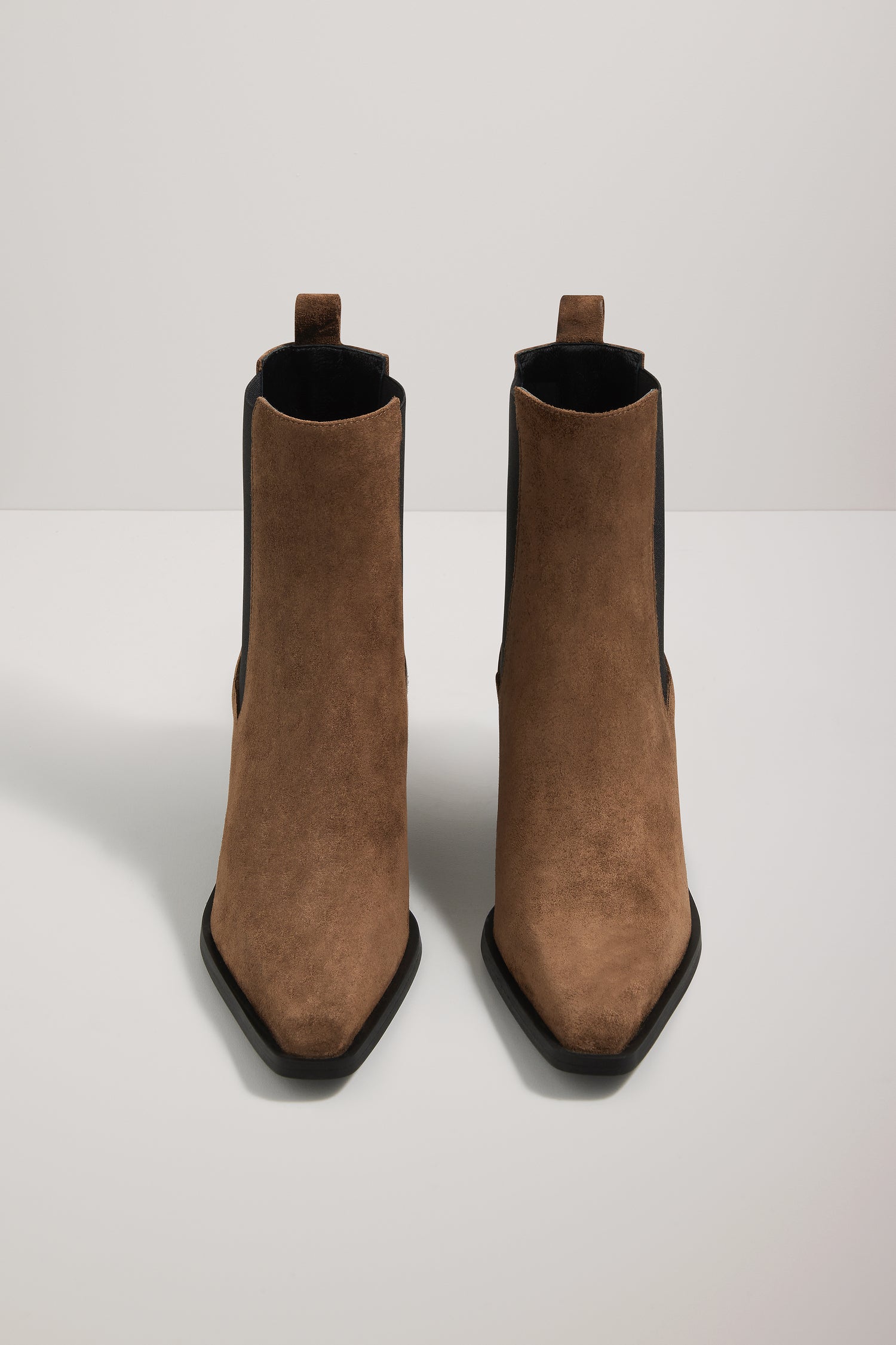 Pair of brown suede ankle boots on a white background