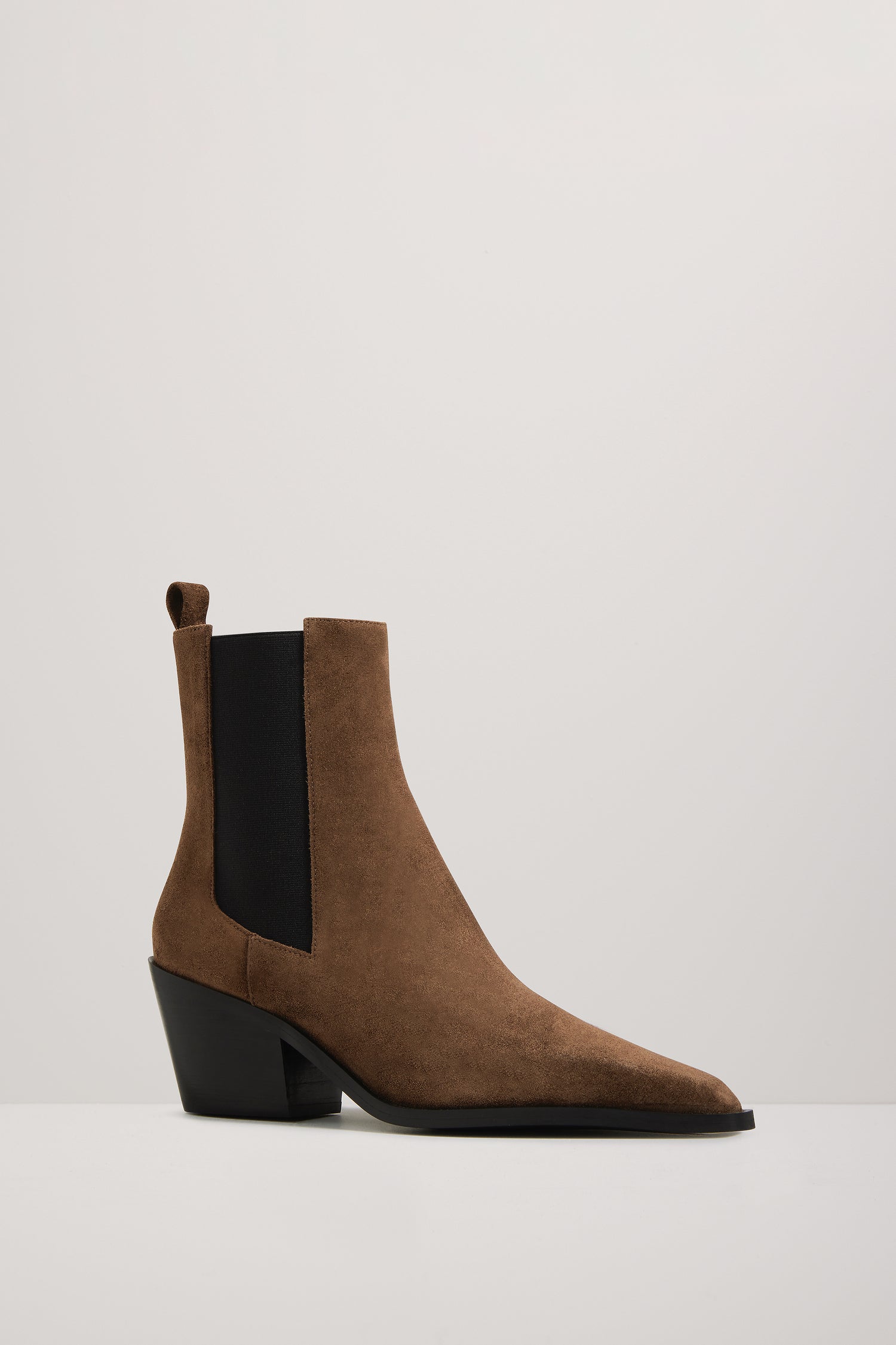 Brown suede ankle boot with black sole on a white background