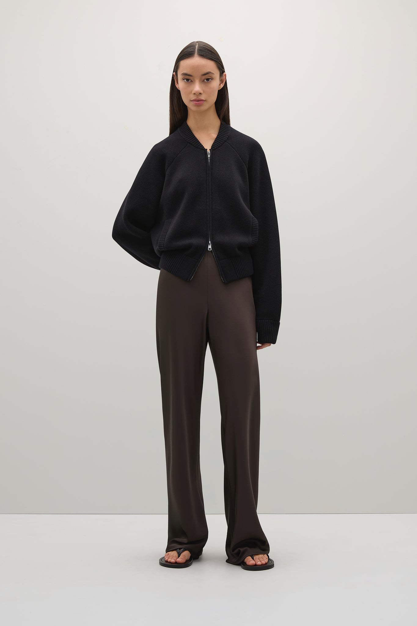 Person wearing a black outfit with a plain background