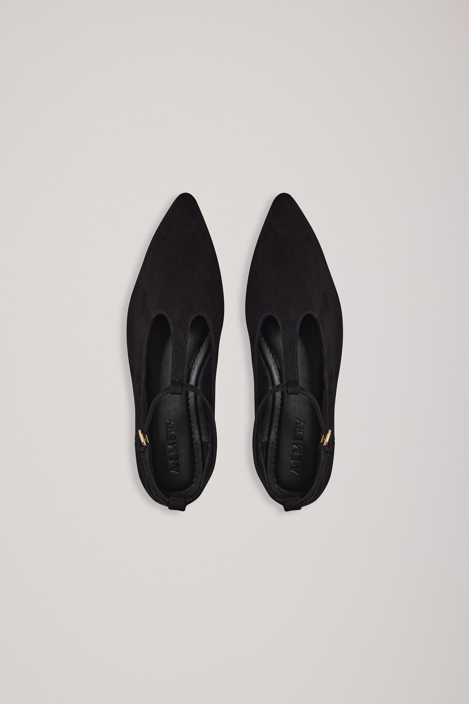Pair of black pointed-toe shoes on a light gray background