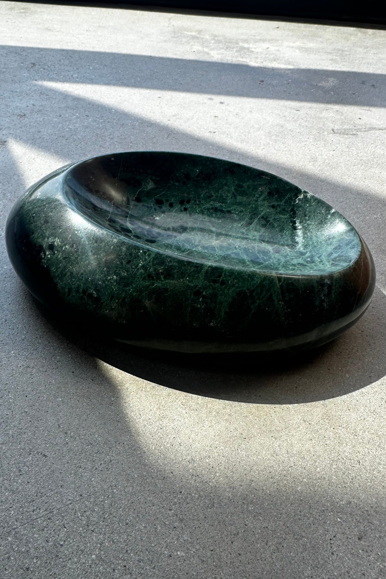Emerald stone bowl on a gray surface