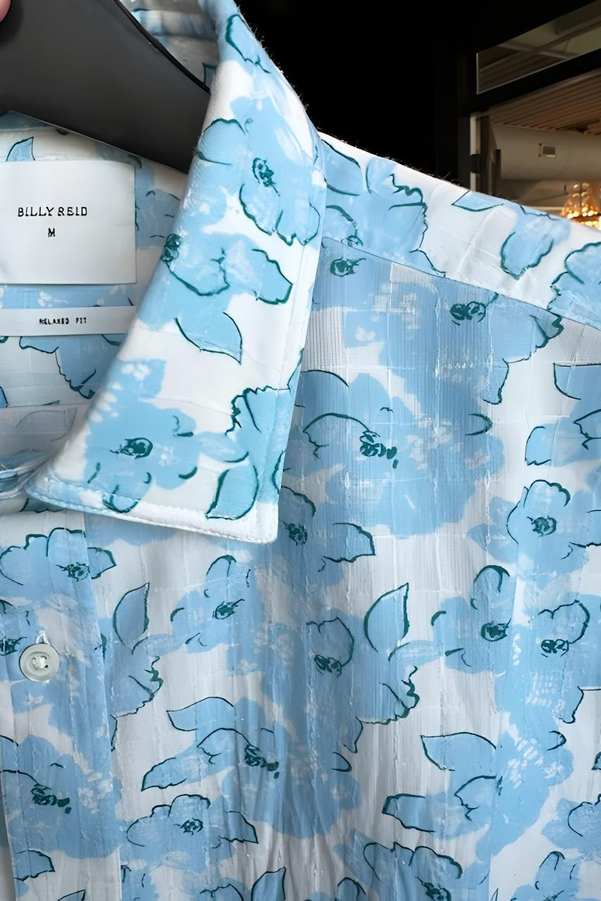 Blue floral patterned shirt with a visible brand label on a dark background