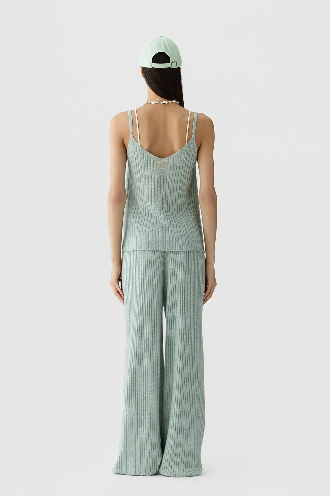 Back image of a model wearing the Guest in Residence Breezy Rib Tank in Sage Brush