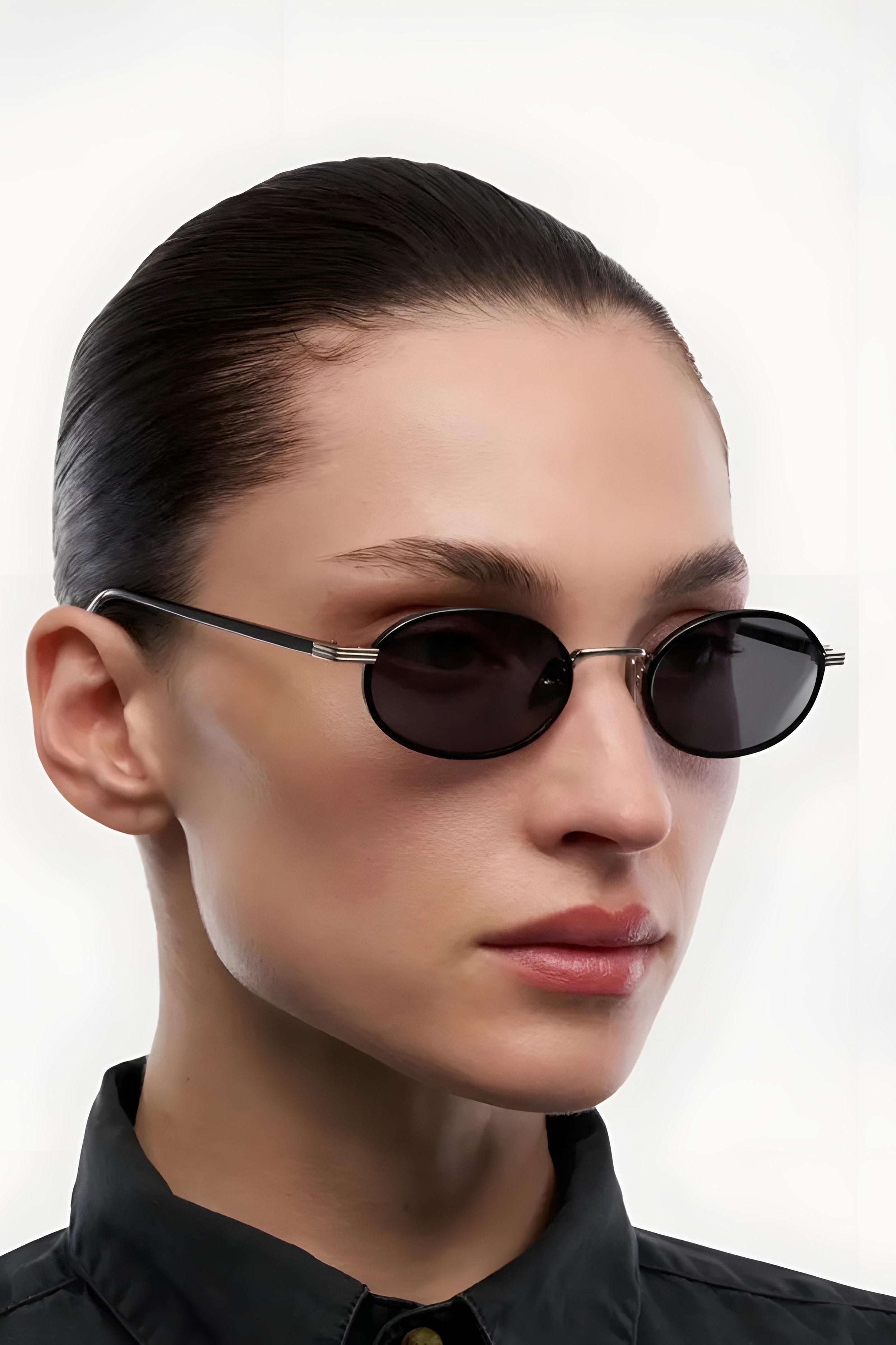 Person wearing a pair of sunglasses with a plain background