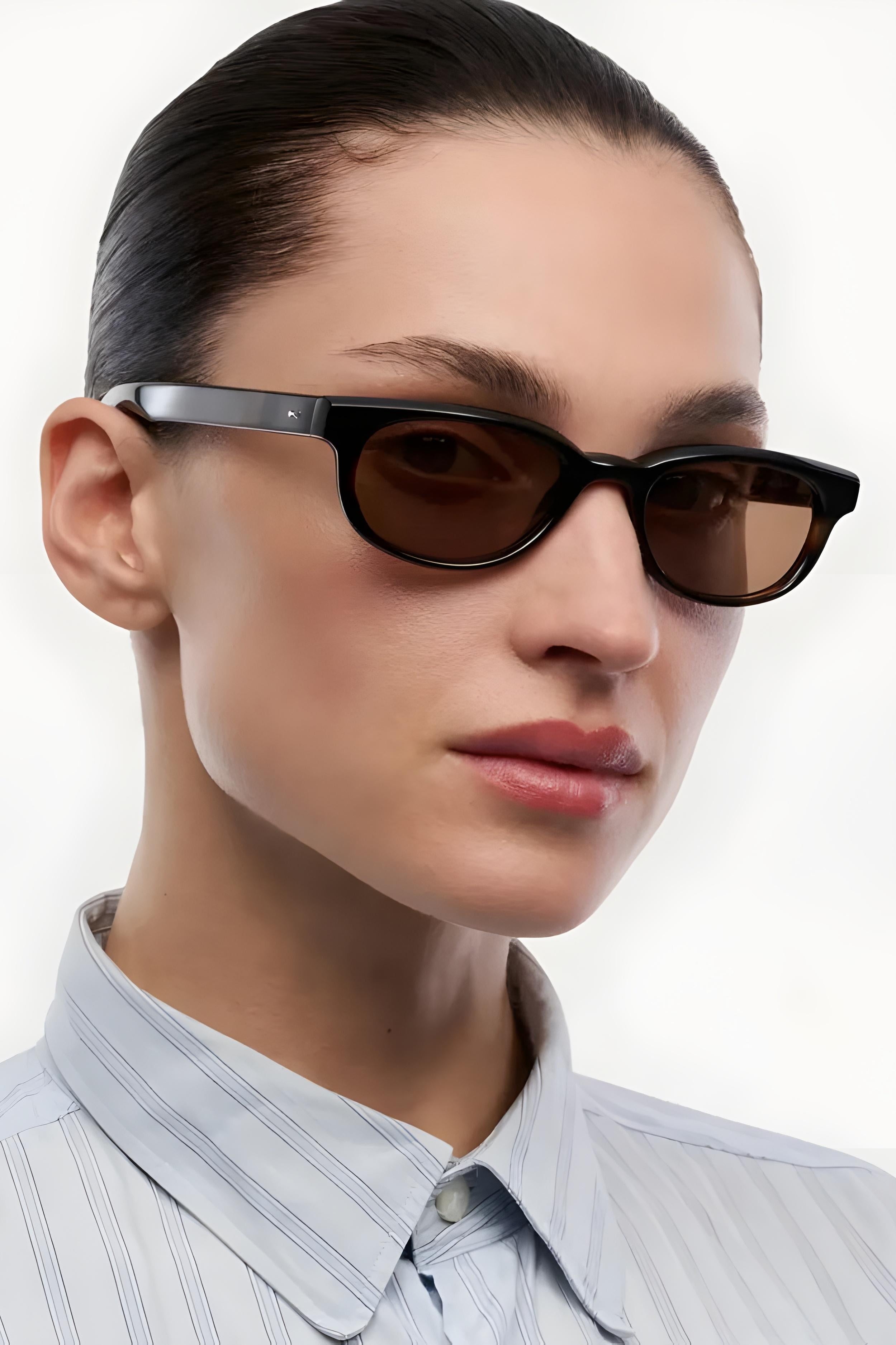 Person wearing dark sunglasses with a neutral background