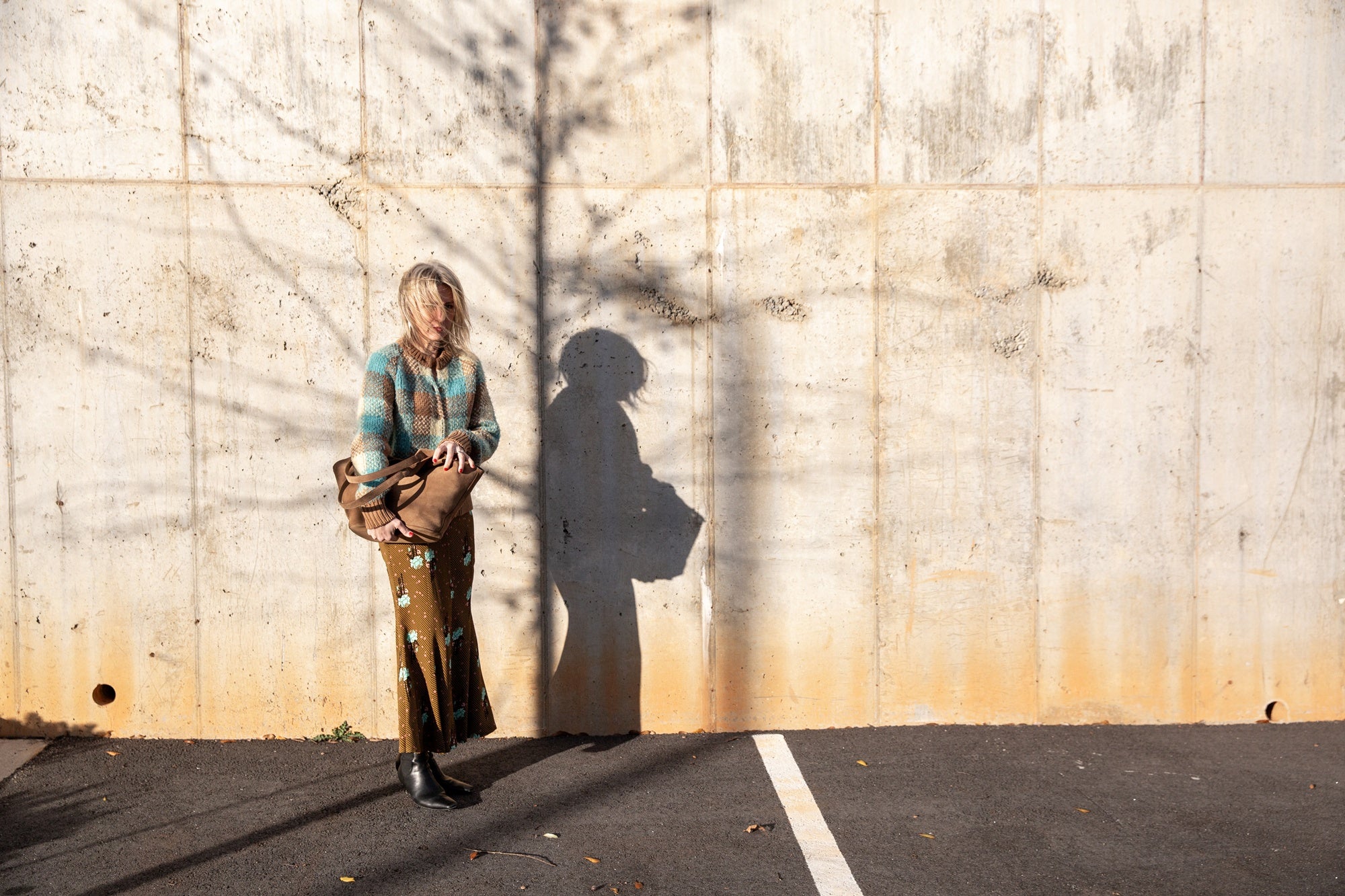 image of a woman wearing the Guest in Residence Buffalo Plaid Cardigan and Rachel Comey Blushing Skirt with an Aesther Ekme Handbag