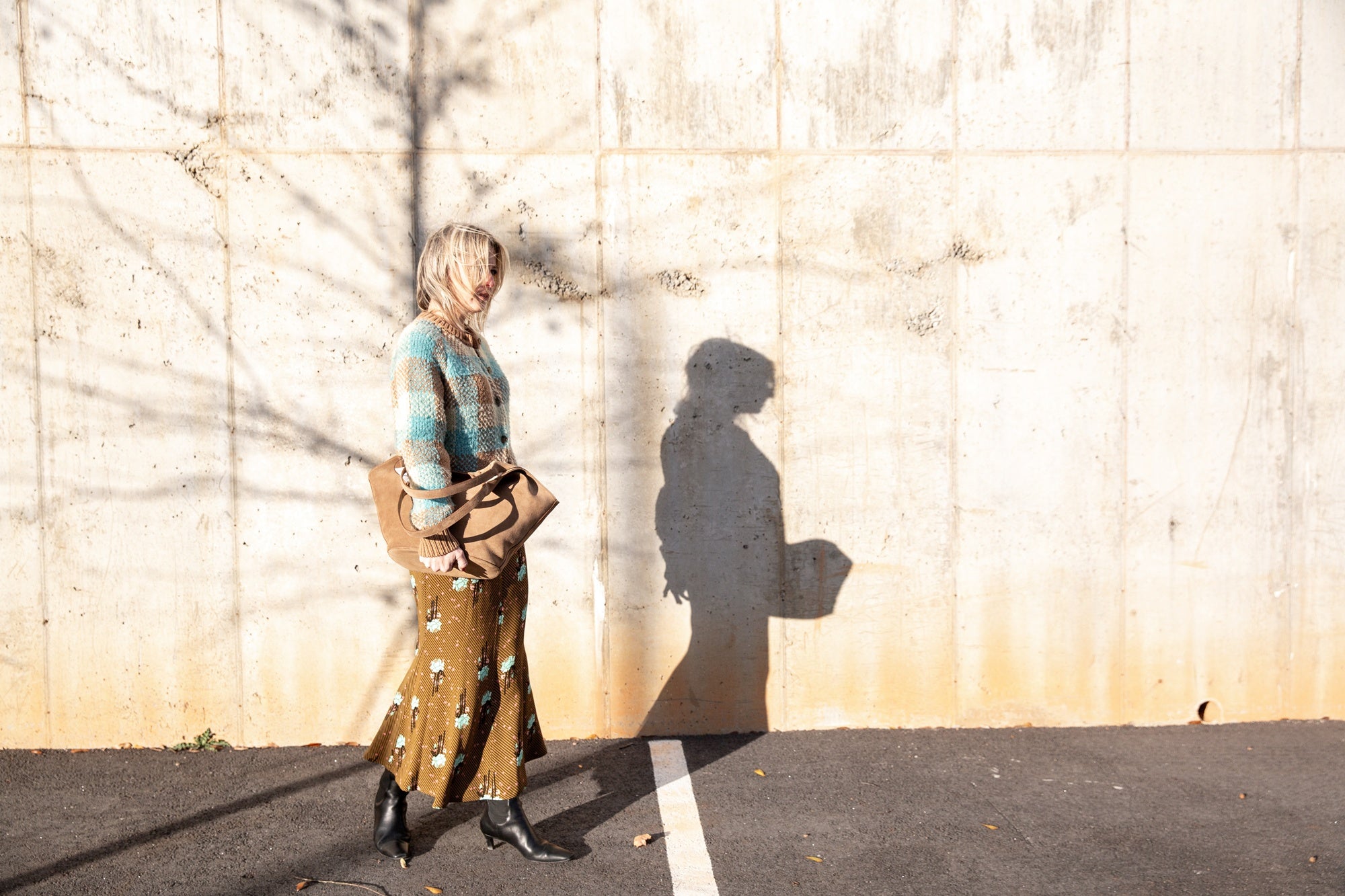 image of a woman wearing the Guest in Residence Buffalo Plaid Cardigan and Rachel Comey Blushing Skirt with an Aesther Ekme Handbag