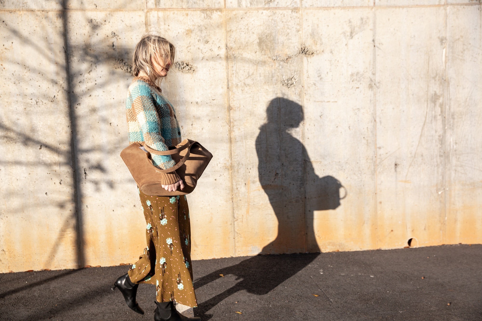 image of a woman wearing the Guest in Residence Buffalo Plaid Cardigan and Rachel Comey Blushing Skirt with an Aesther Ekme Handbag