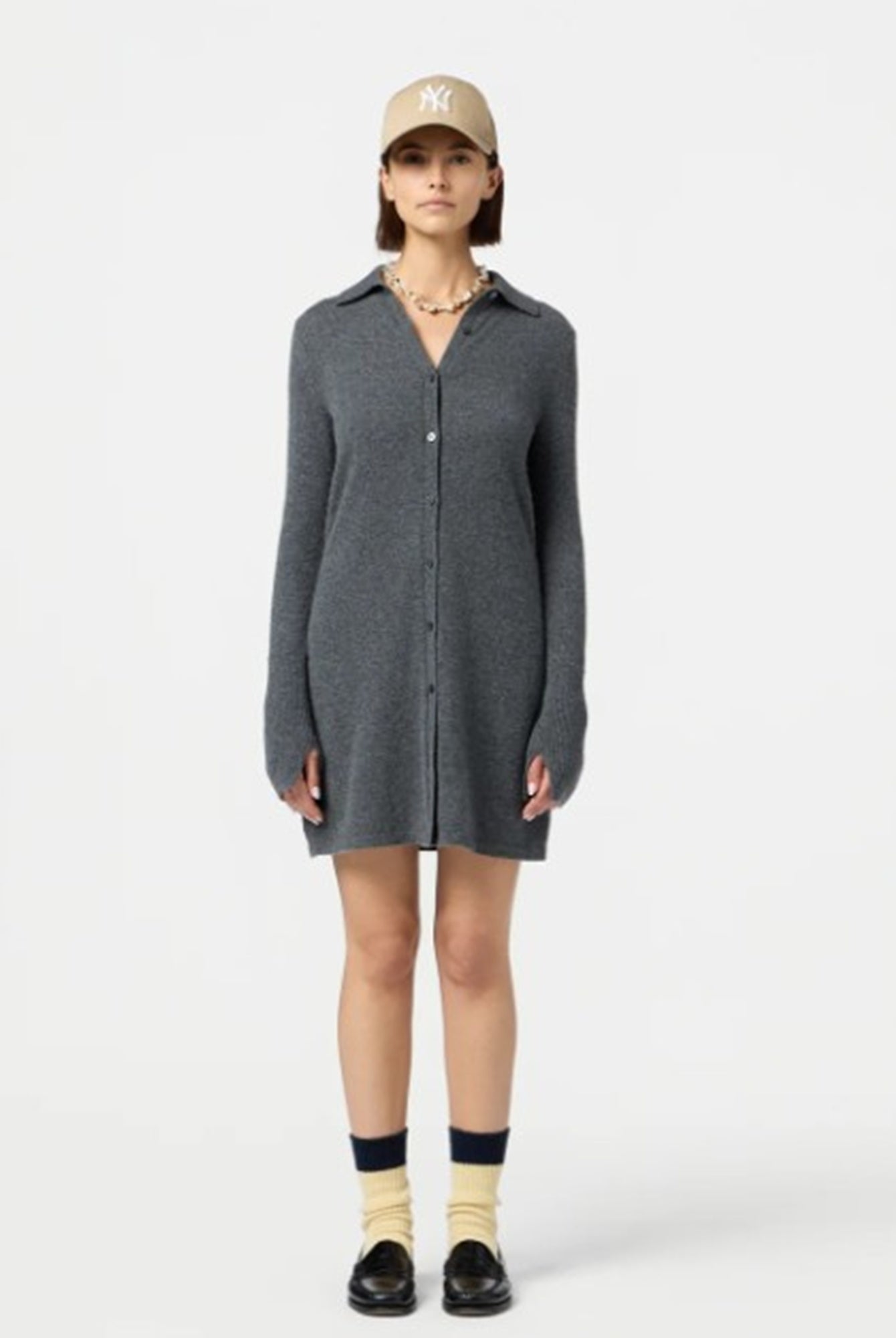 Person wearing a gray dress with a white background