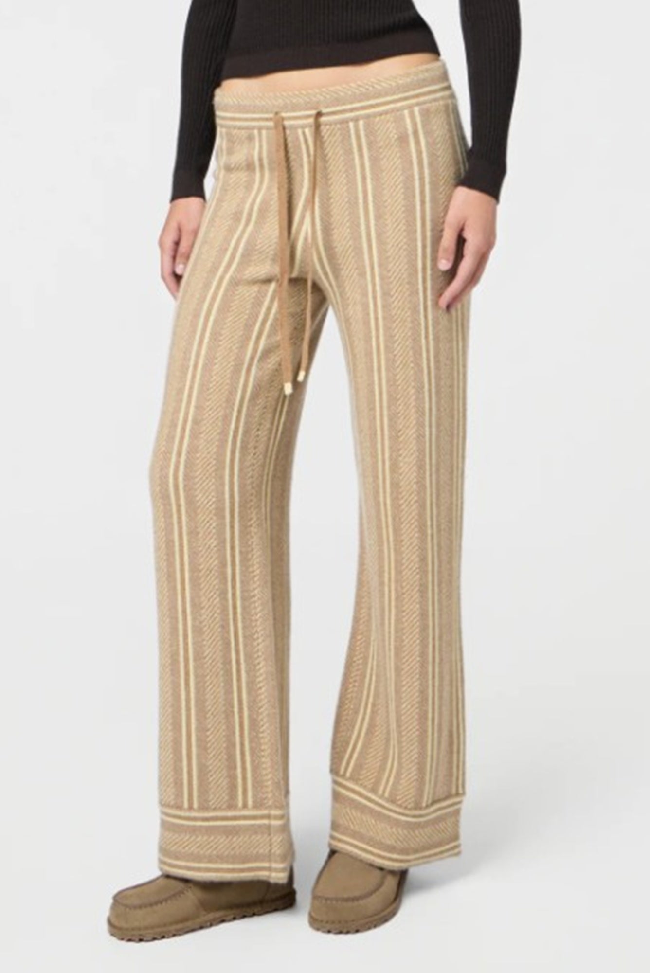 Beige striped pants worn by a person on a white background