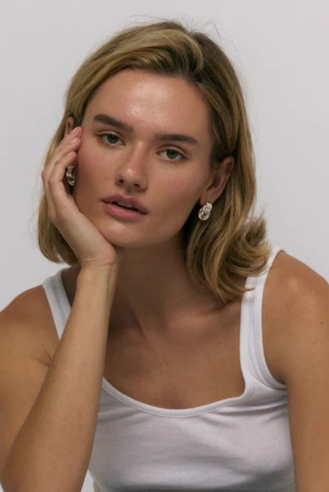 image of a model wearing the heaven mayhem baby knot earrings in silver