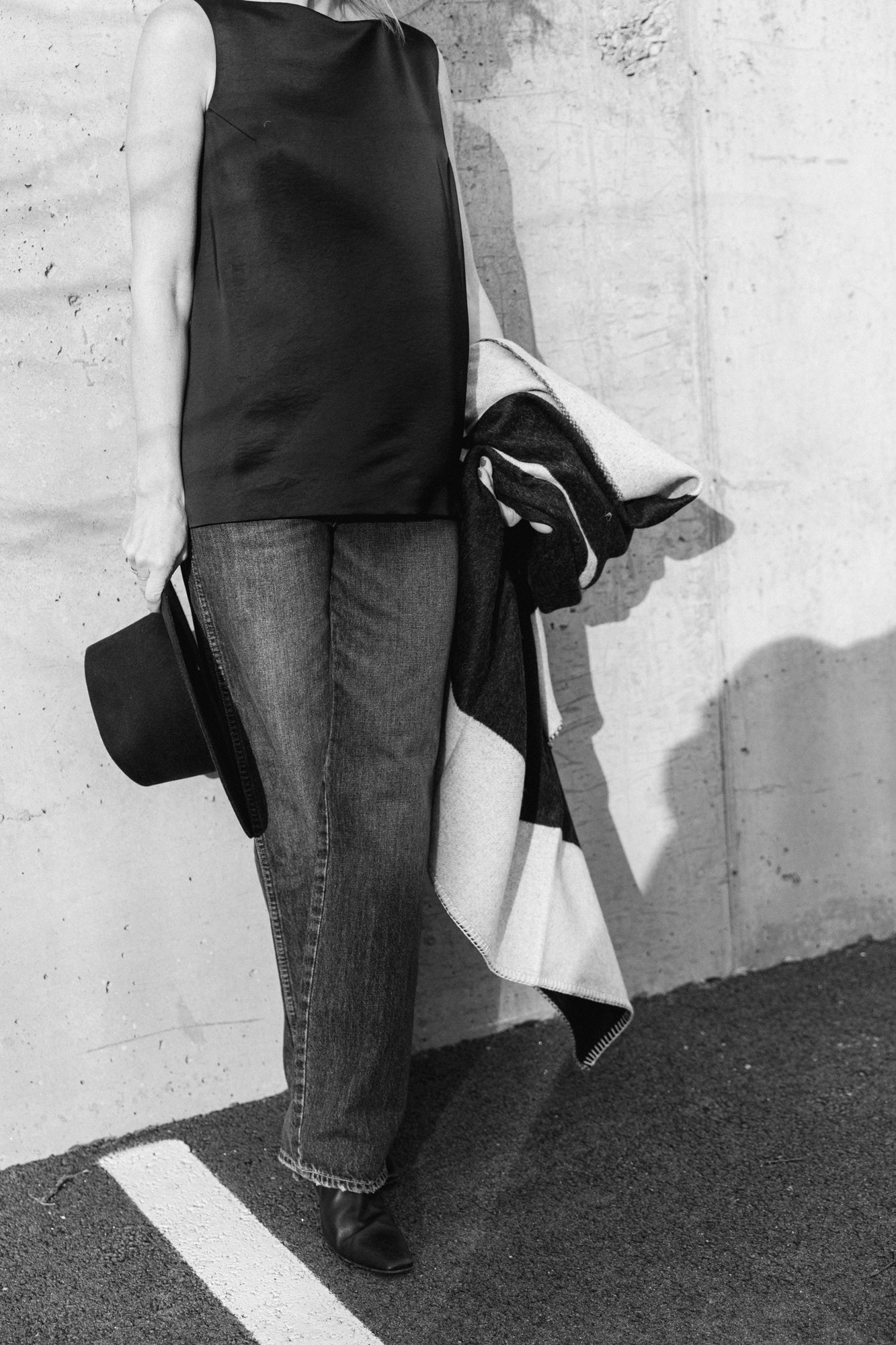 image of a model wearing a house of dagmar open back satin top, amo annette jeans in persuasion with a janessa leone hat