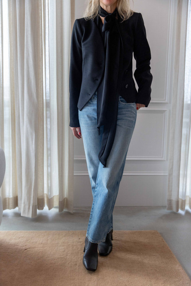 Dagmar Chiffon Scarf Blouse in black viscose, full-length front view with black jacket, straight denim and boots