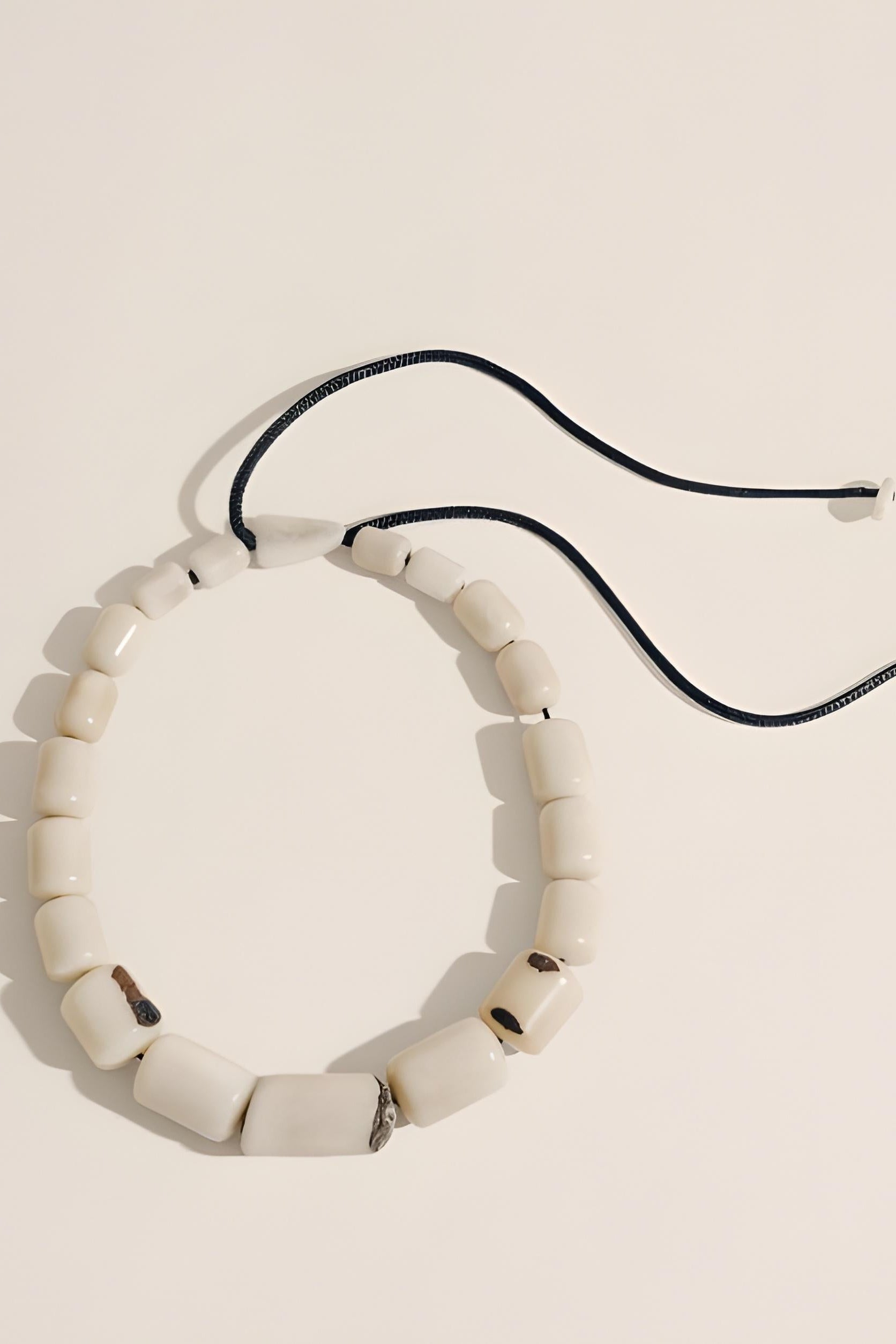 Necklace with white beads on a beige background