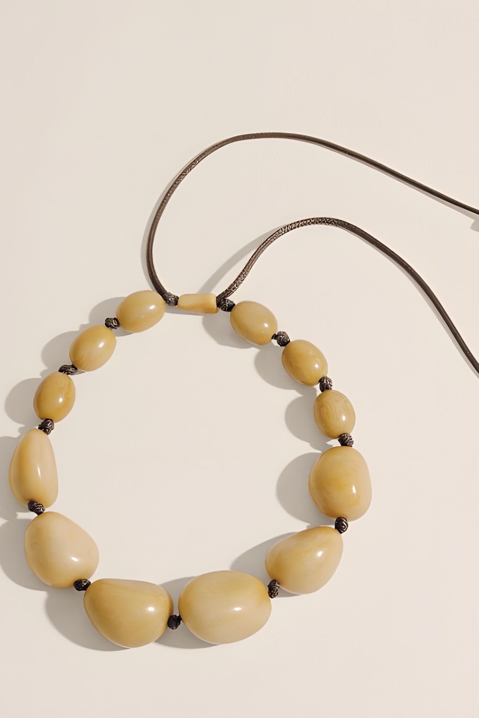 Necklace with beige beads on a beige background