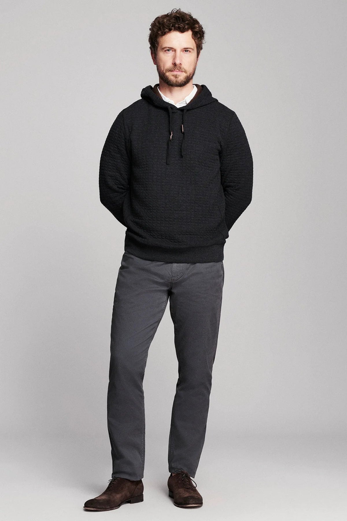 Billy Reid Box Quilt Hoodie Pullover in black quilted cotton jacquard, worn front view with charcoal trousers and brown shoes