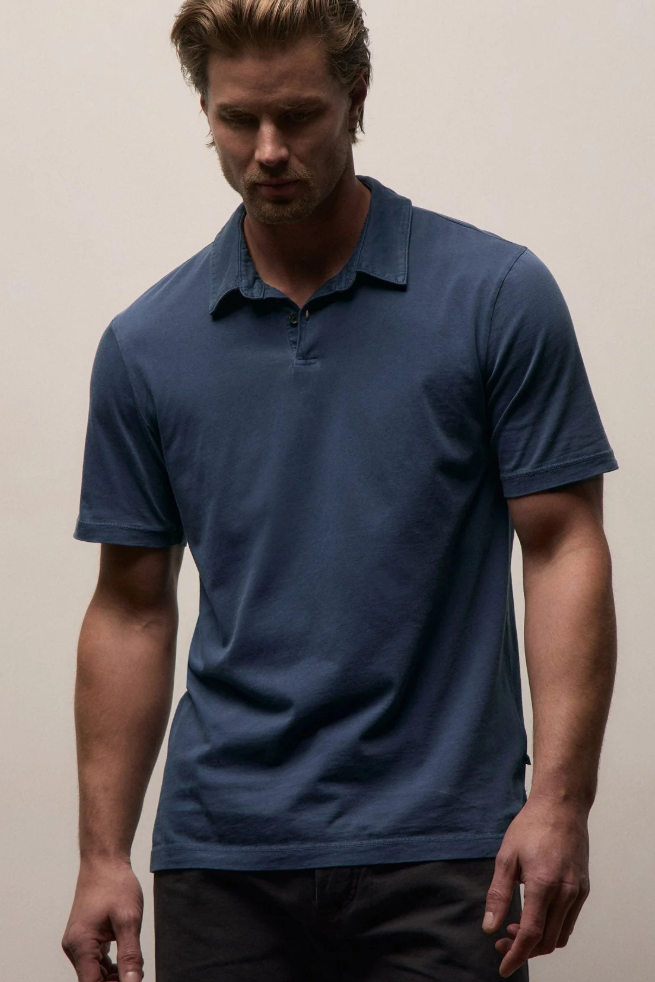 Man wearing a blue polo shirt against a plain background