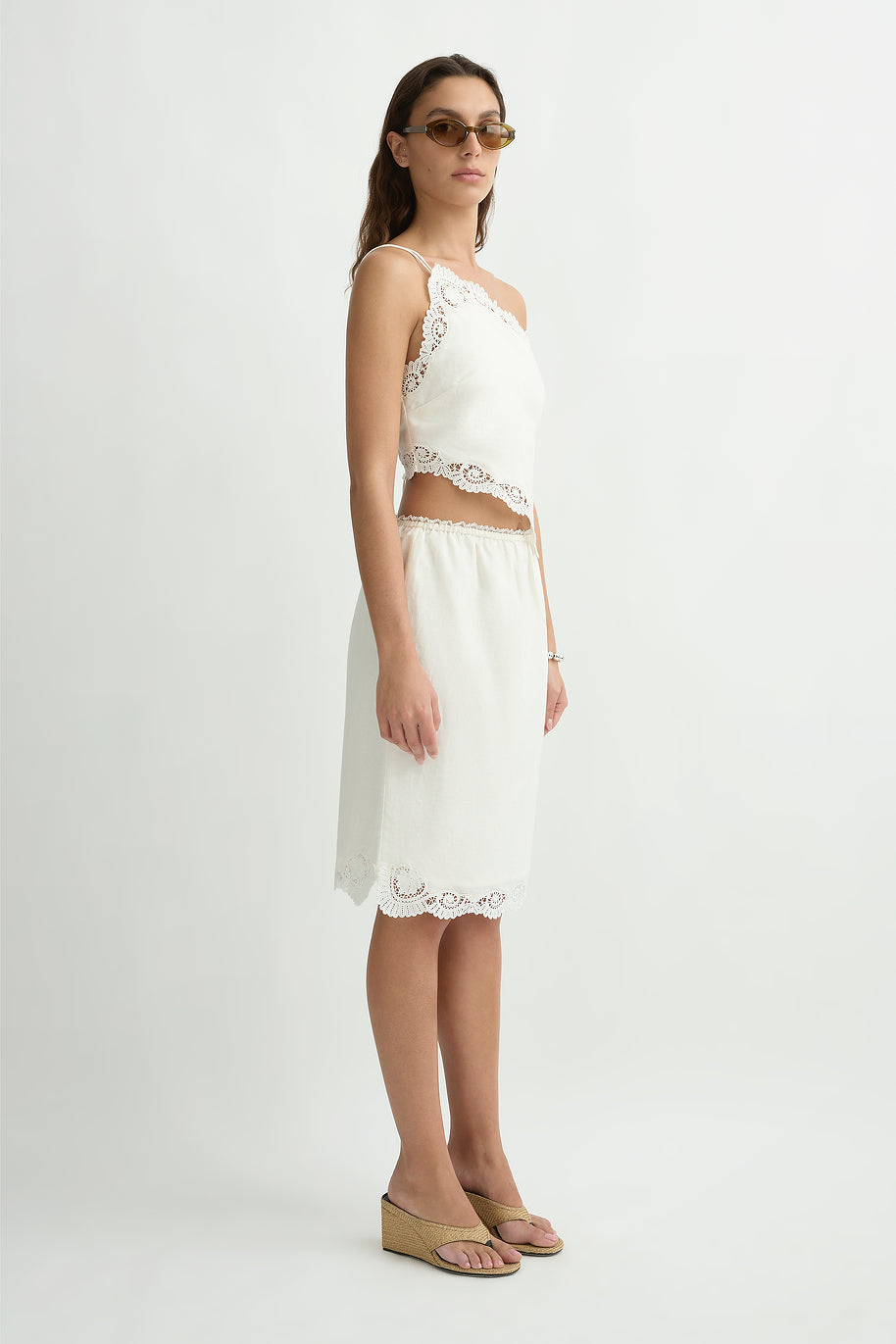 Woman wearing the posse darya top standing in front of a cream background