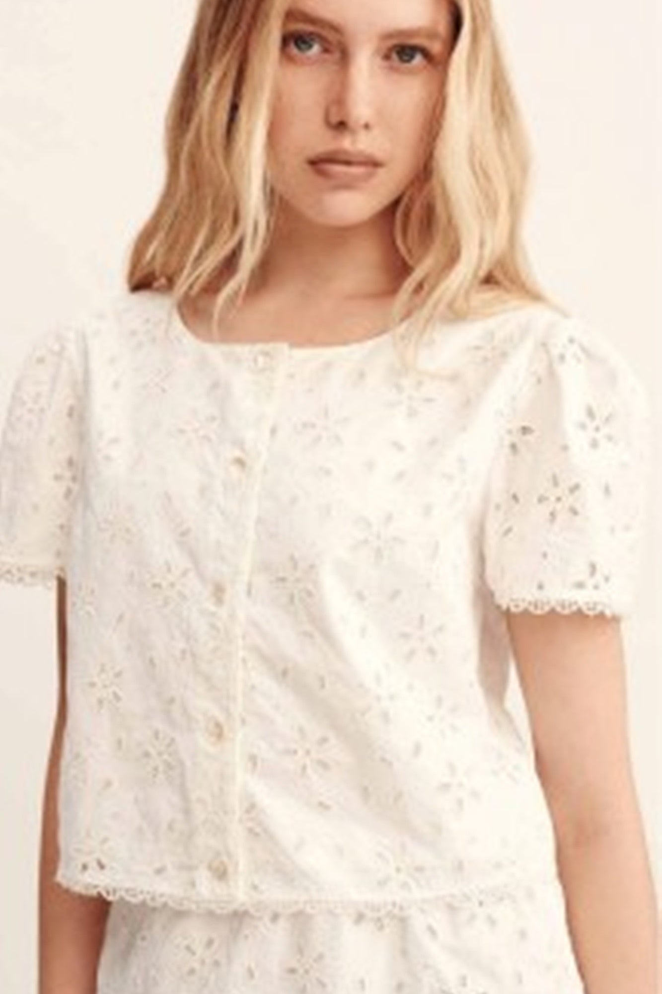 image of a model wearing the Posse salma cap sleeve top in vintage white