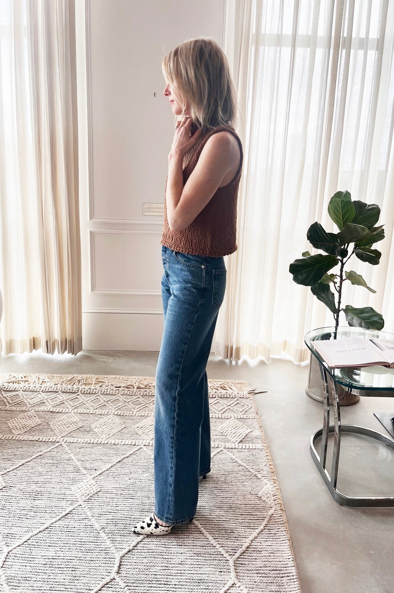 image of a woman wearing the Sablyn Atticus top and sammy relaxed jeans with the Studio Amelia Alto Cow Mules