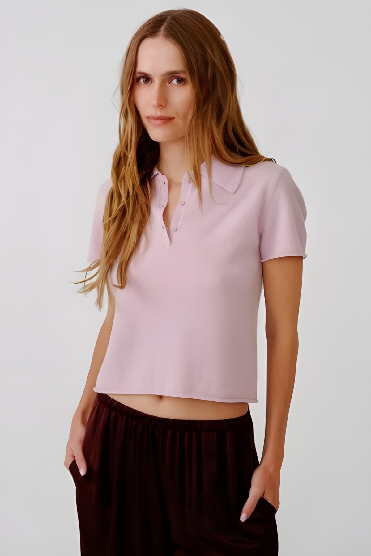 Woman standing against white background wearing the sablyn Rita Short Sleeve Polo sweater 