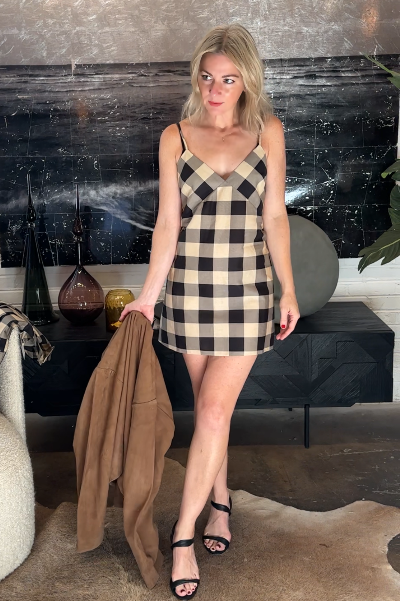 Woman in a checkered dress standing in a modern interior setting