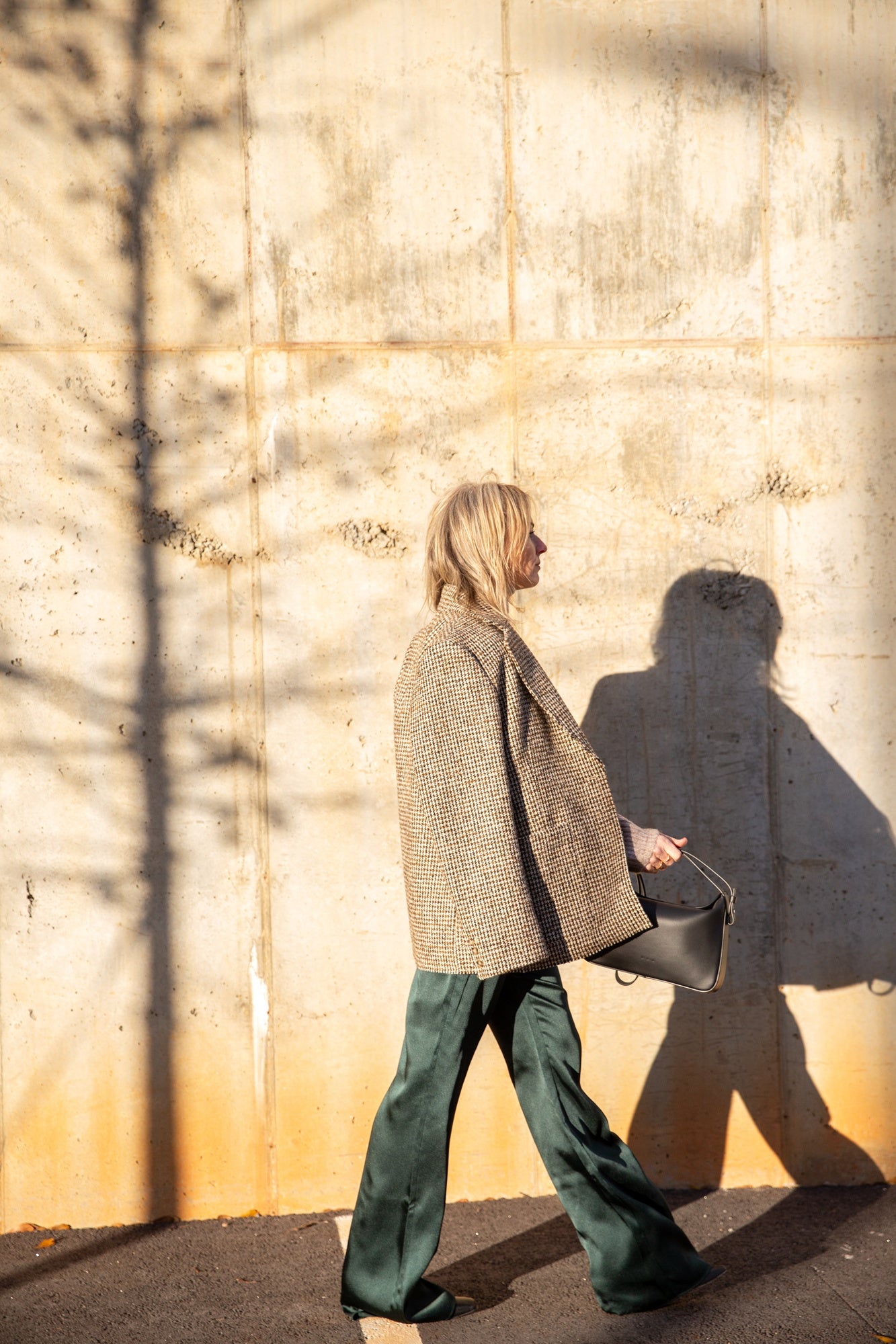 image of a woman wearing the Seroya Viva Satin Pants with the House of Dagmar Tweed Coat and Aesther Ekme Handbag