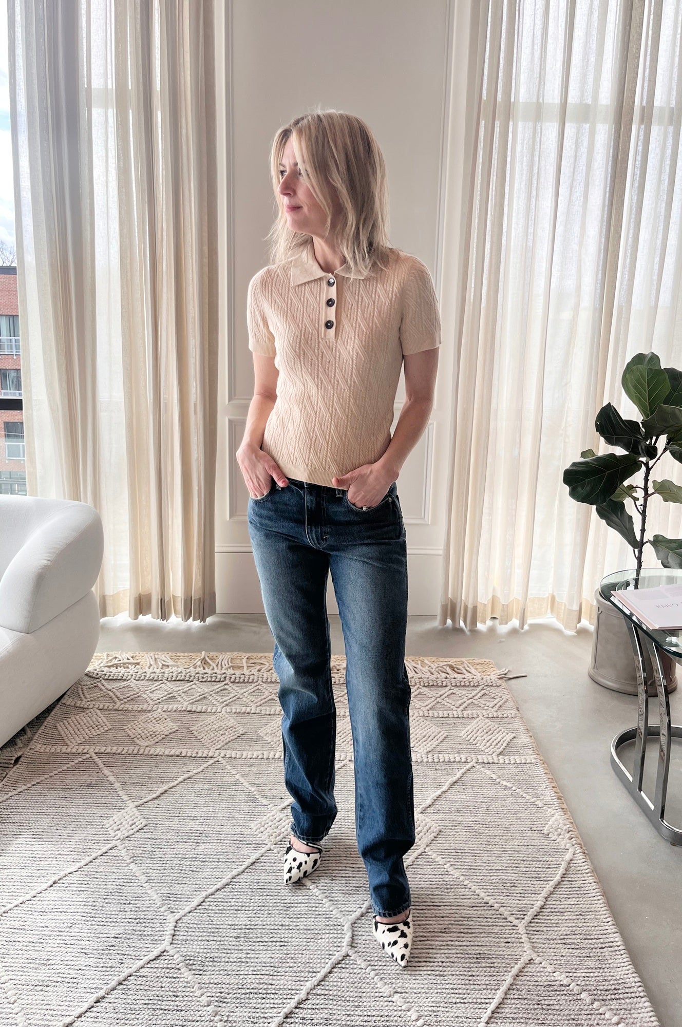 image of a woman wearing the Garment Como Cable Mini Polo, Amo Mira Jeans and Studio Amelia Alto Cow Mules