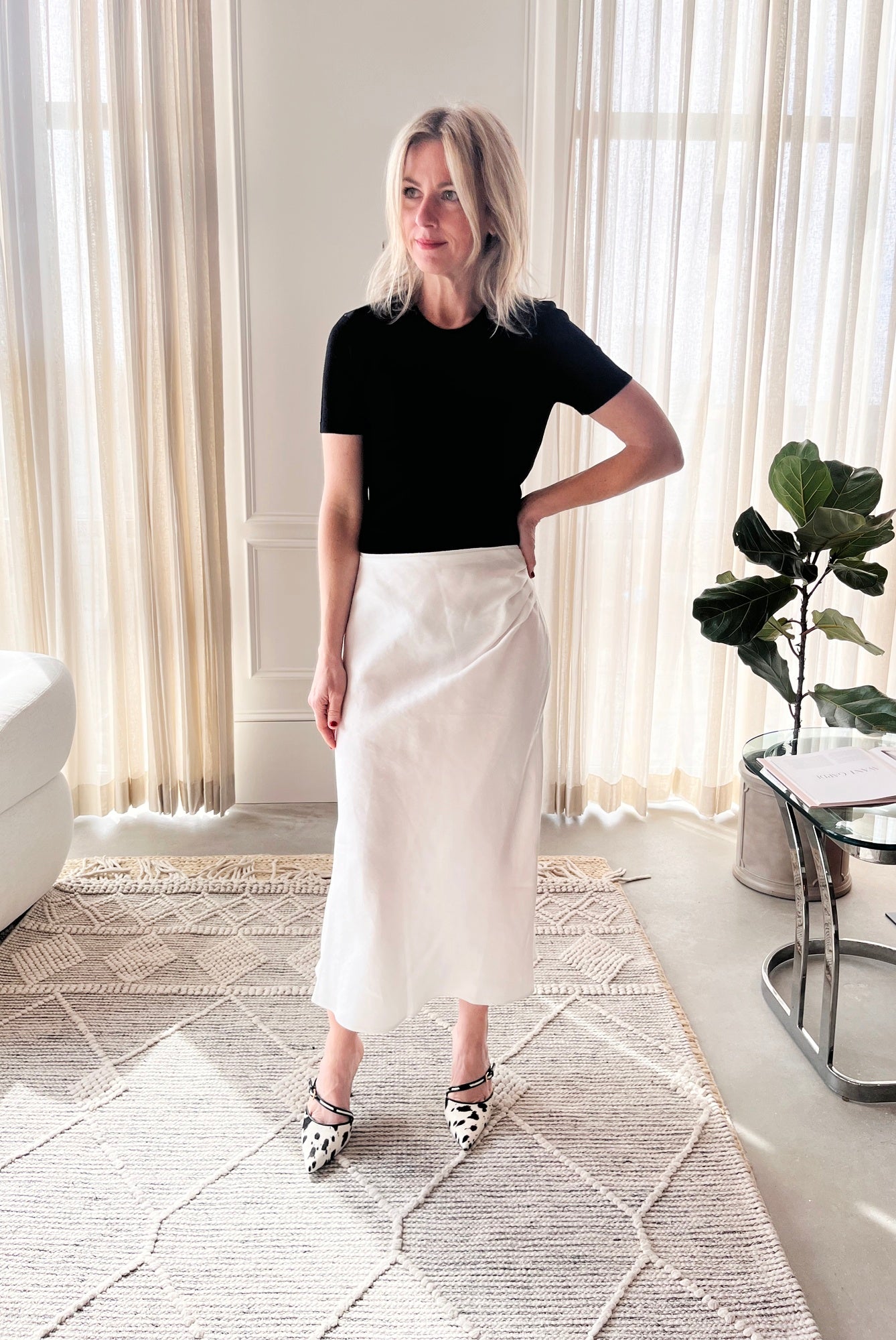 image of a woman wearing the Garment Bergen Knit Tee and House of Dagmar Draped Skirt with Studio Amelia Alto Cow Heels