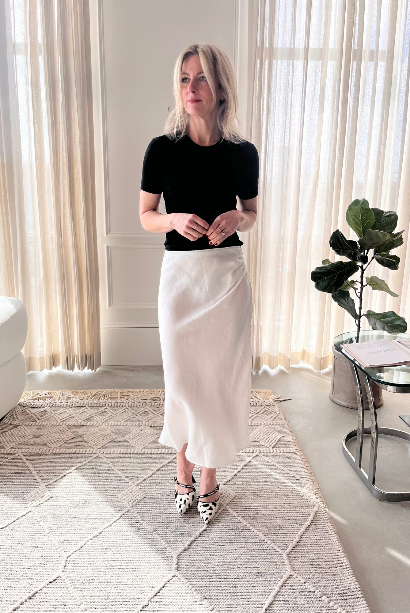 image of a woman wearing the Garment Bergen Knit Tee and House of Dagmar Draped Skirt with Studio Amelia Alto Cow Heels