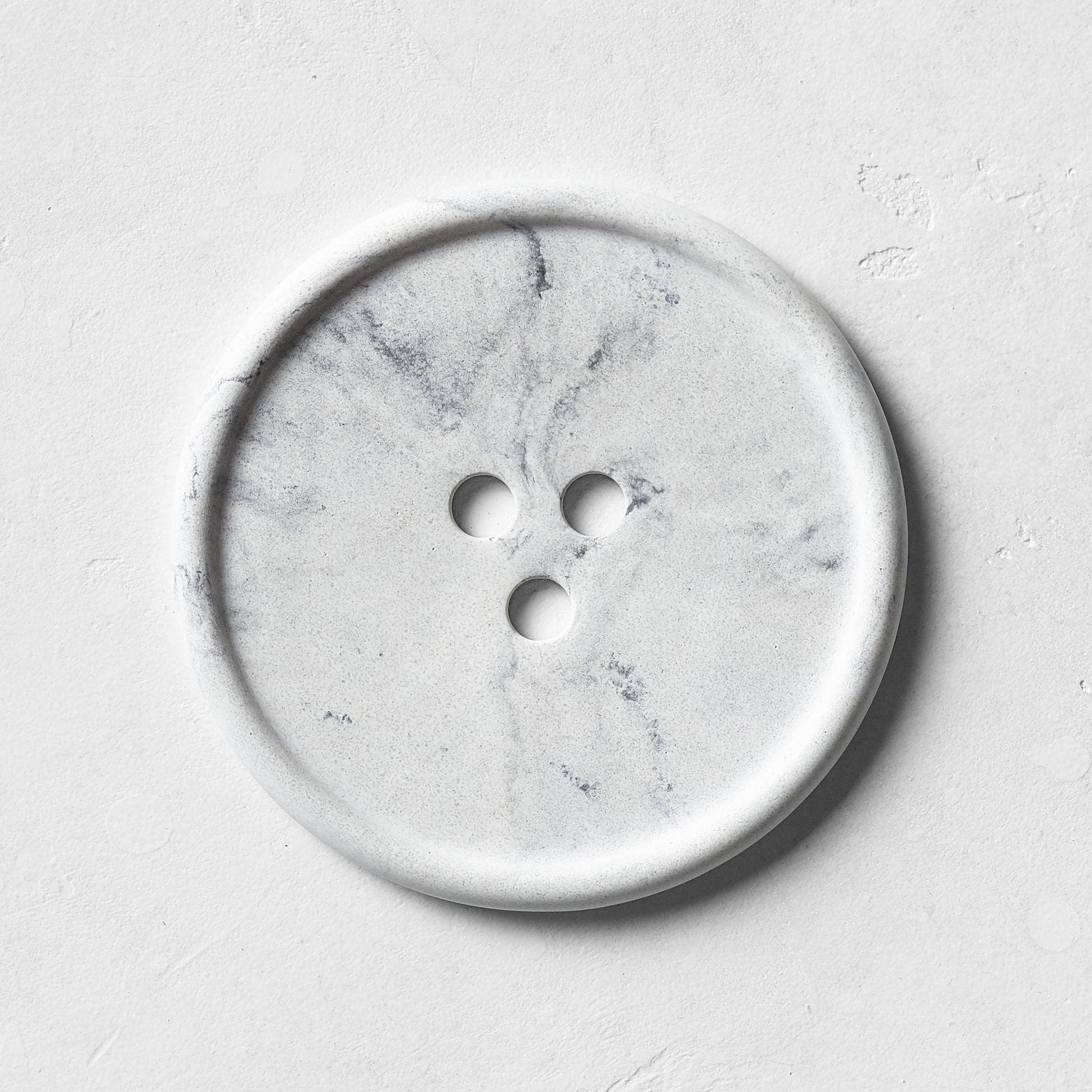 Marble-patterned button on a light gray background
