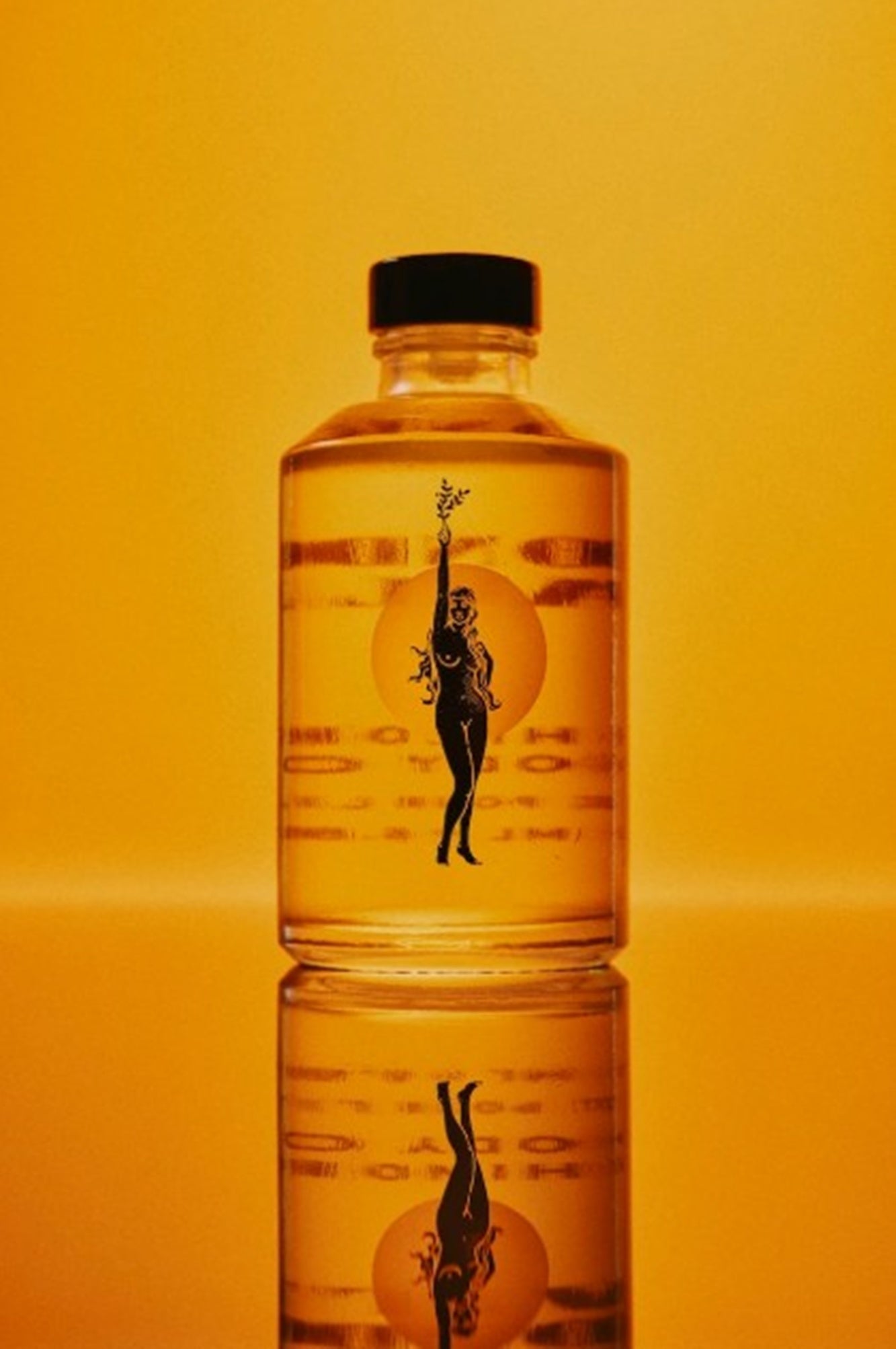 Clear bottle with black cap on an orange background