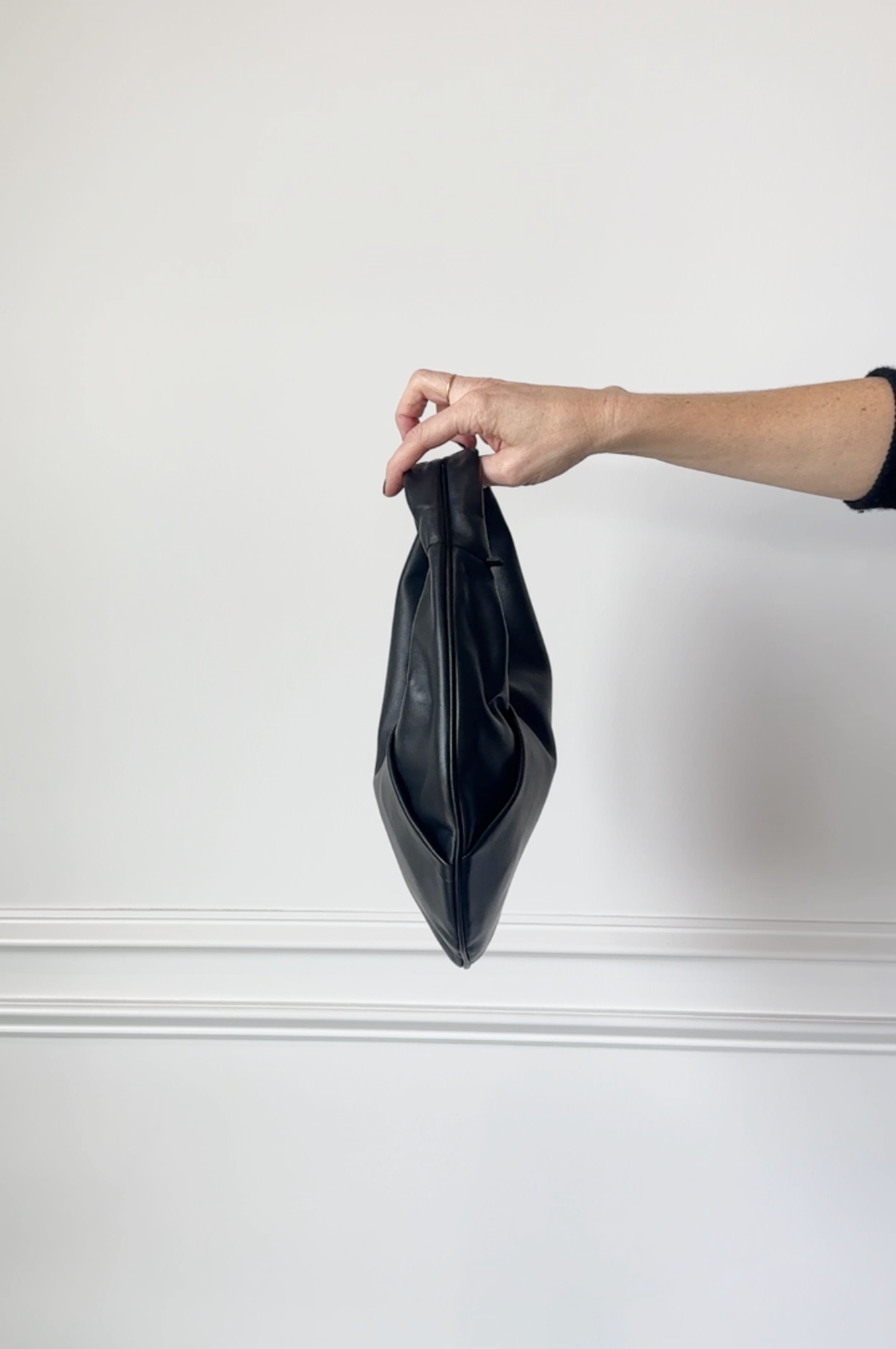 model holding the aesther ekme ora mini handbag in black