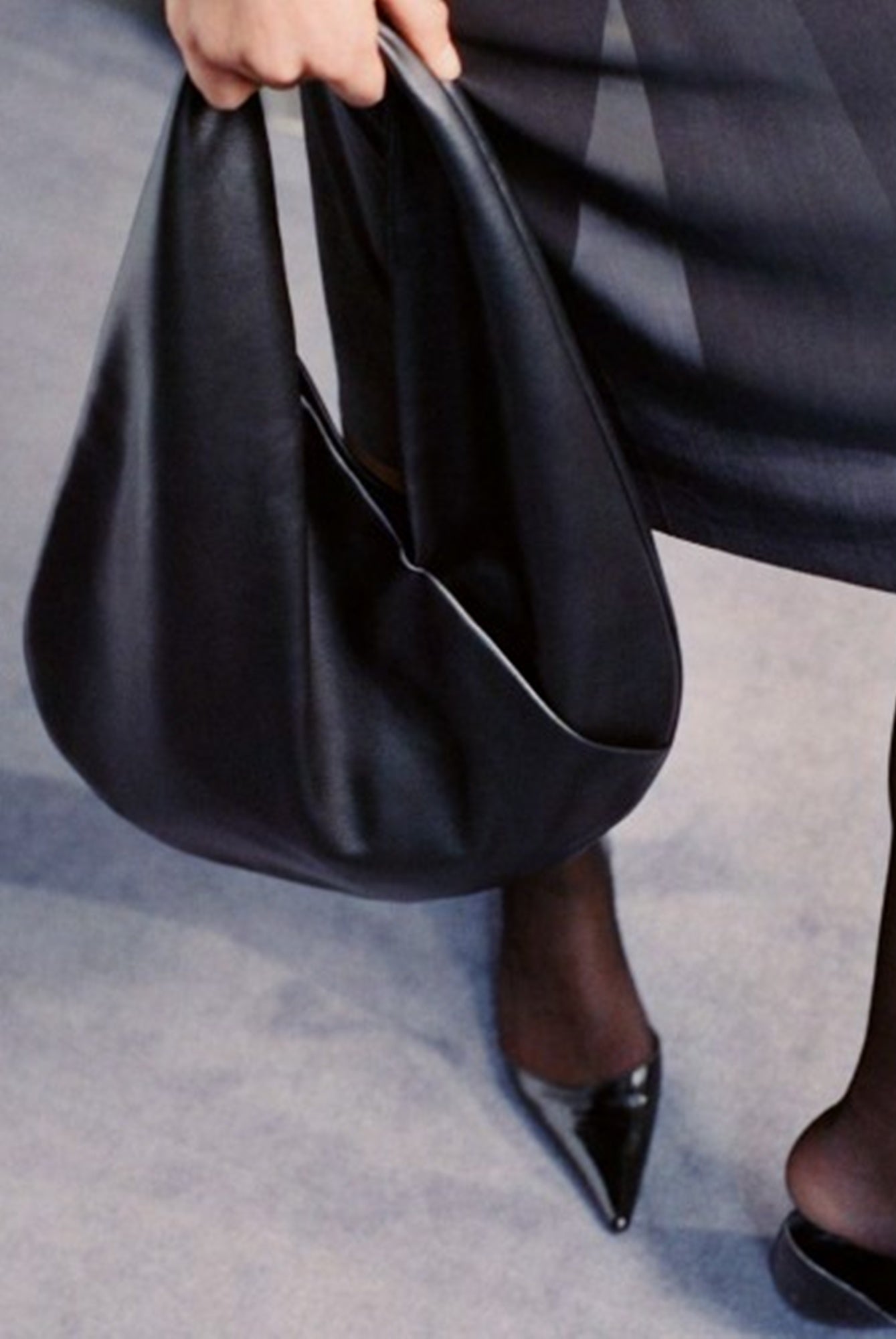 model holding the aesther ekme ora mini handbag in black