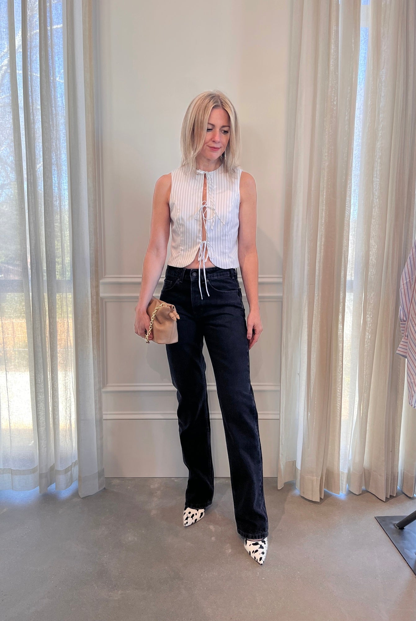 image of a woman wearing the Alfie Neda Striped Top and Jeanerica Silsla Jeans with the Studio Amelia Alexandra Clutch