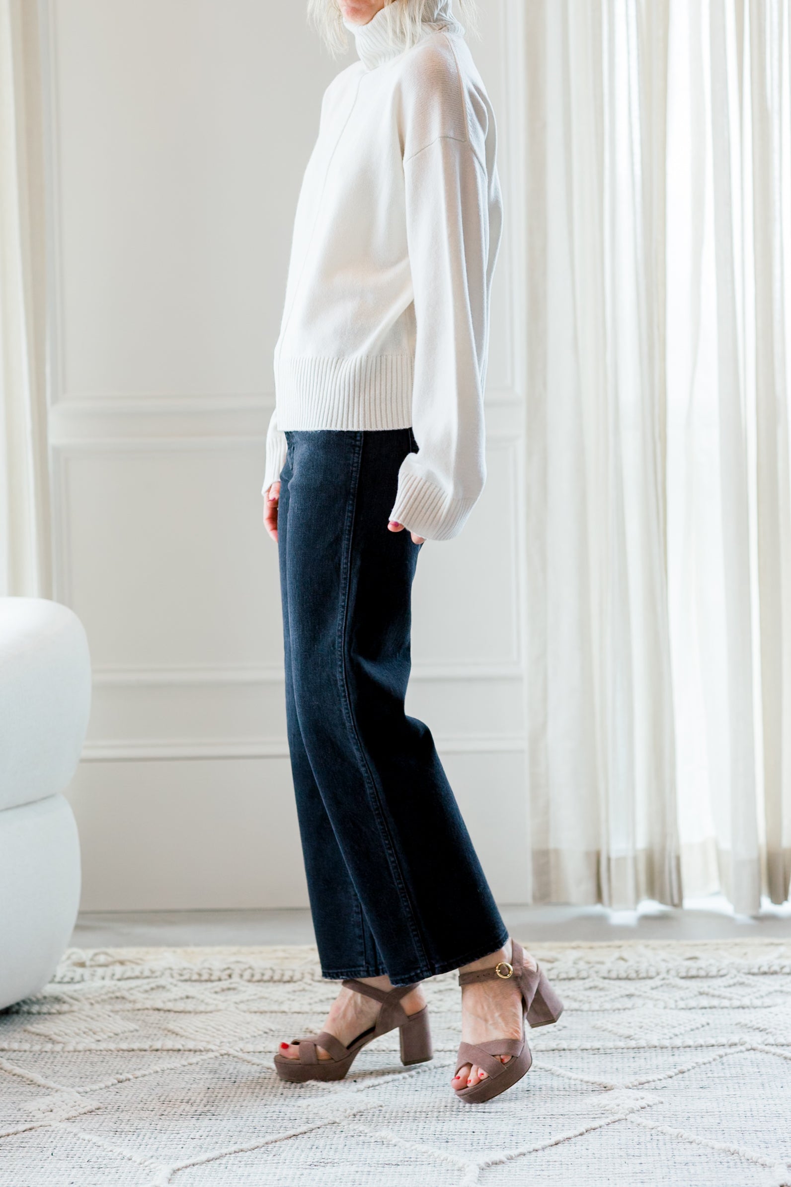 image of a woman wearing the allude turtleneck sweater and amo  billie jeans