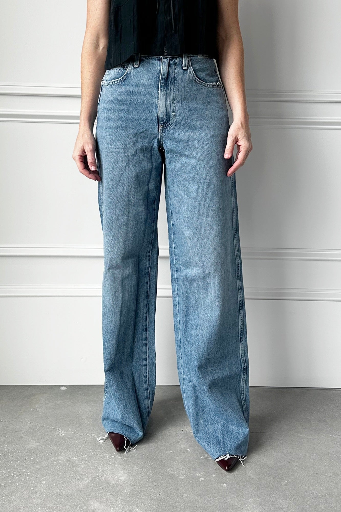 Person wearing light blue wide-leg jeans against a neutral background