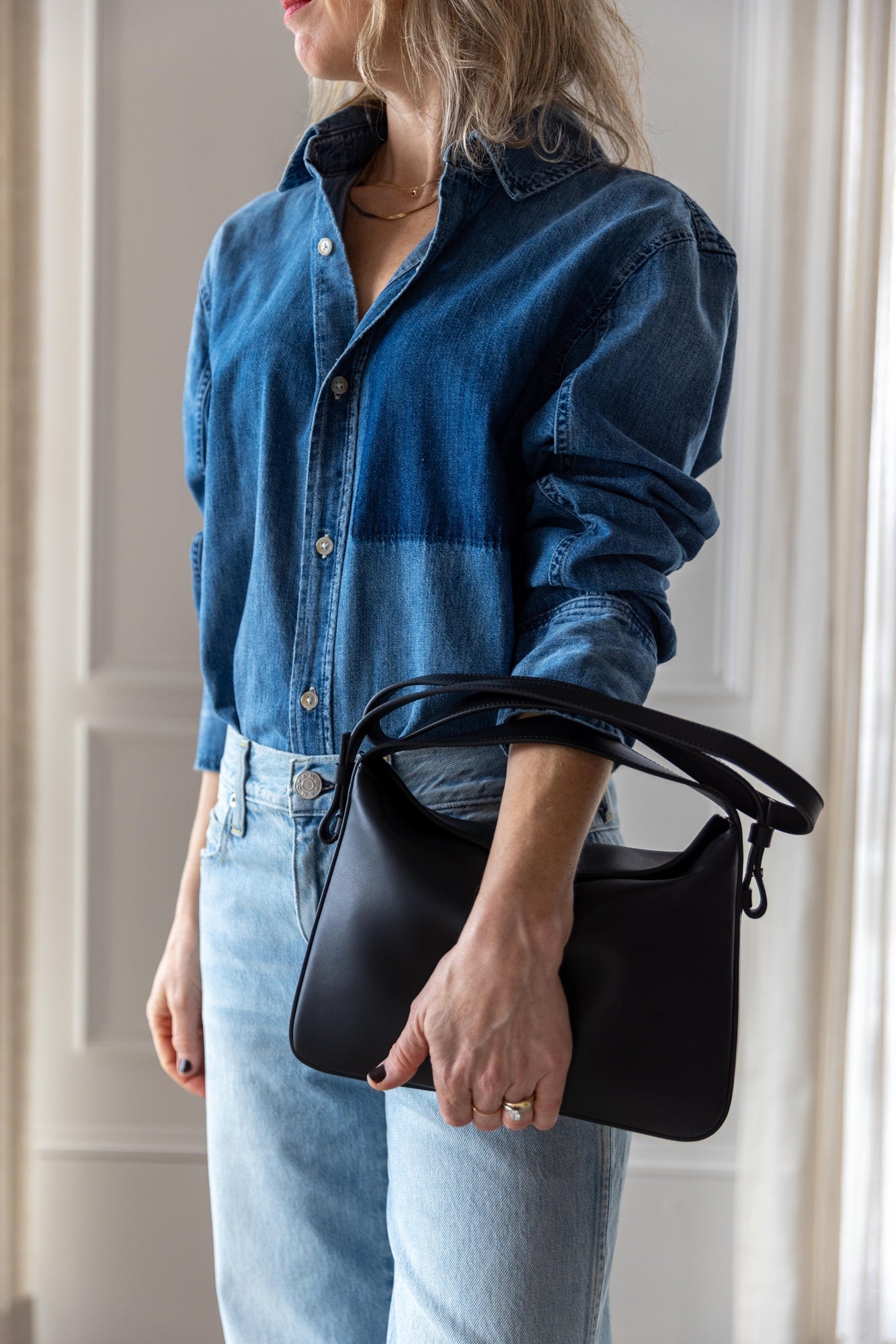 image of woman wearing the Amo Ruth denim shirt and billie jeans with the Aesther Ekme Baguette Bag